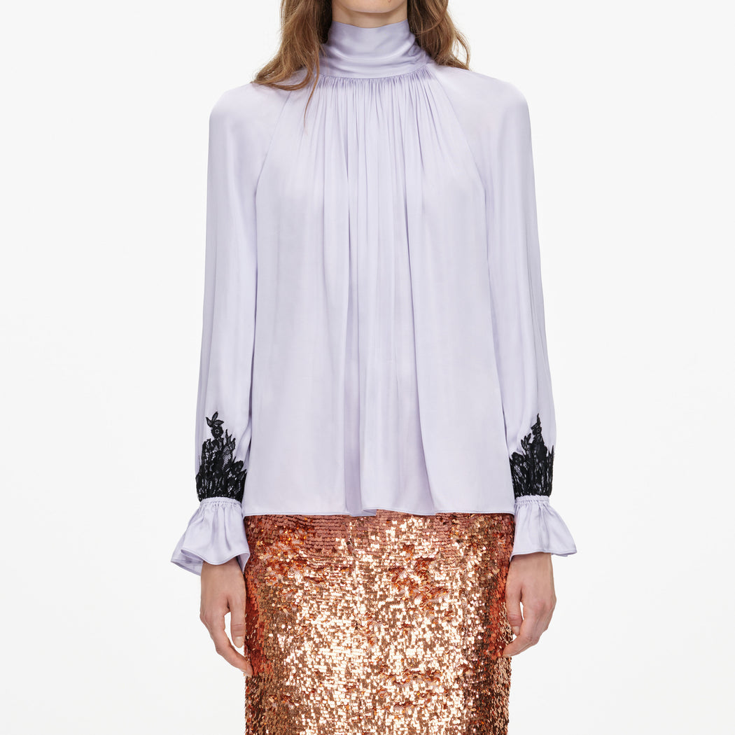 A close up of a woman wearing the Lilac Viscose Contrast Lace Blouse