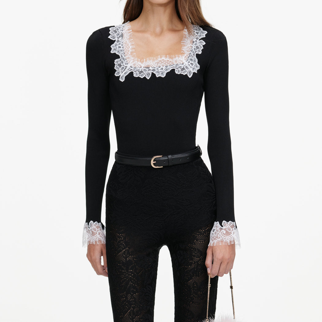 A close up of a woman wearing the Black Capri Lace Knit Leggings
