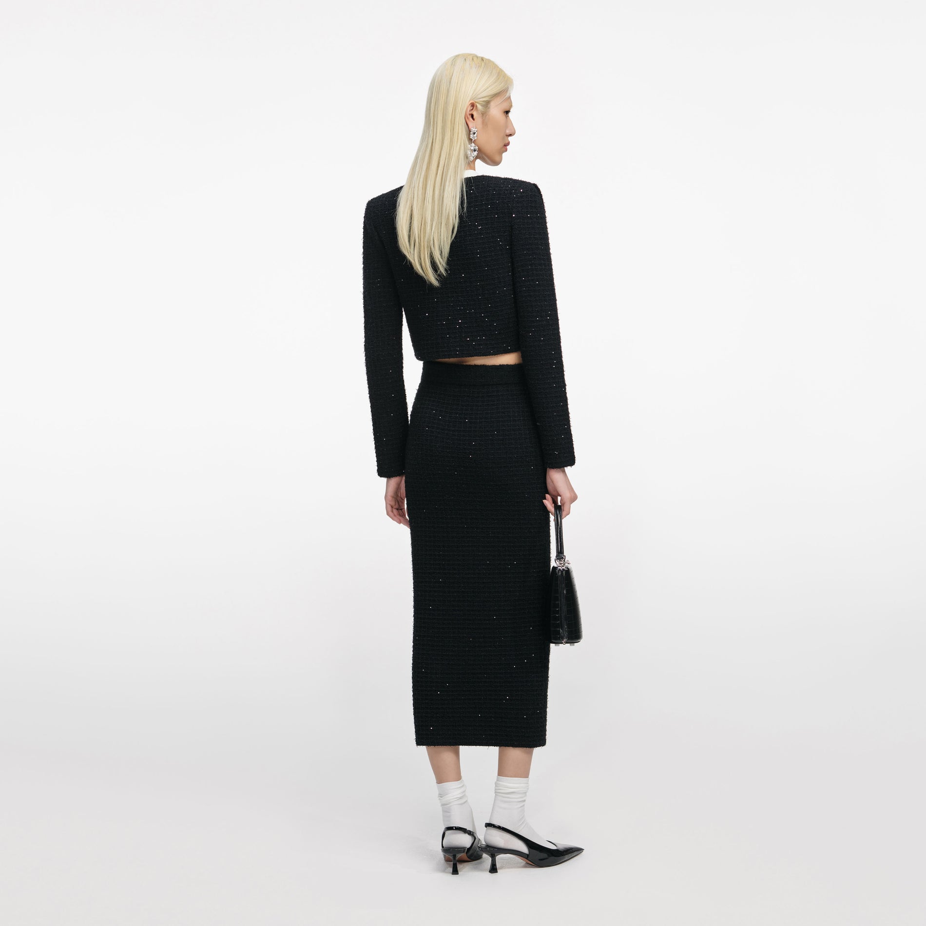 Back view of a woman wearing the Black Floral Textured Knit Jacket