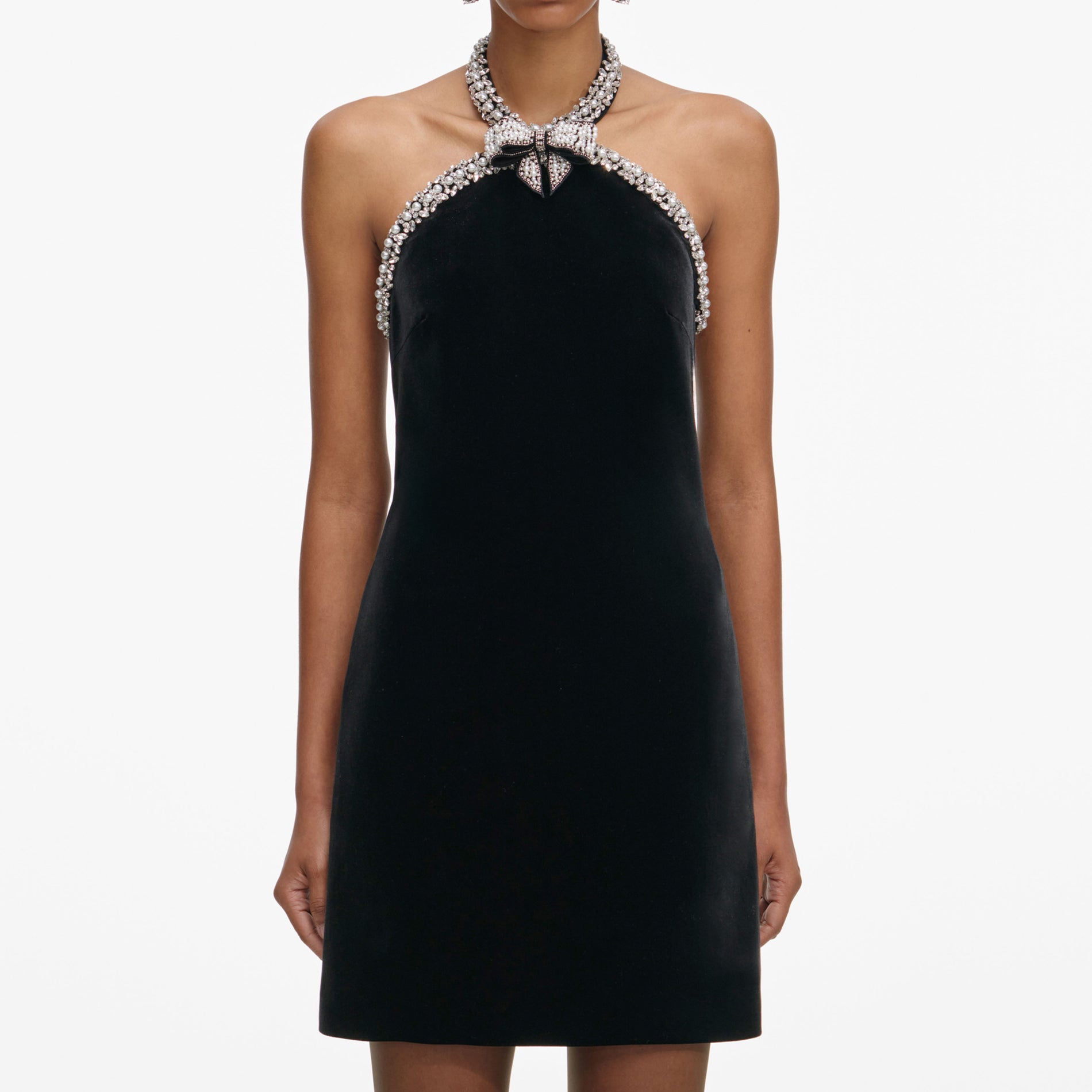 A close up of a woman wearing the Black Velvet Crystal Trim Mini Dress