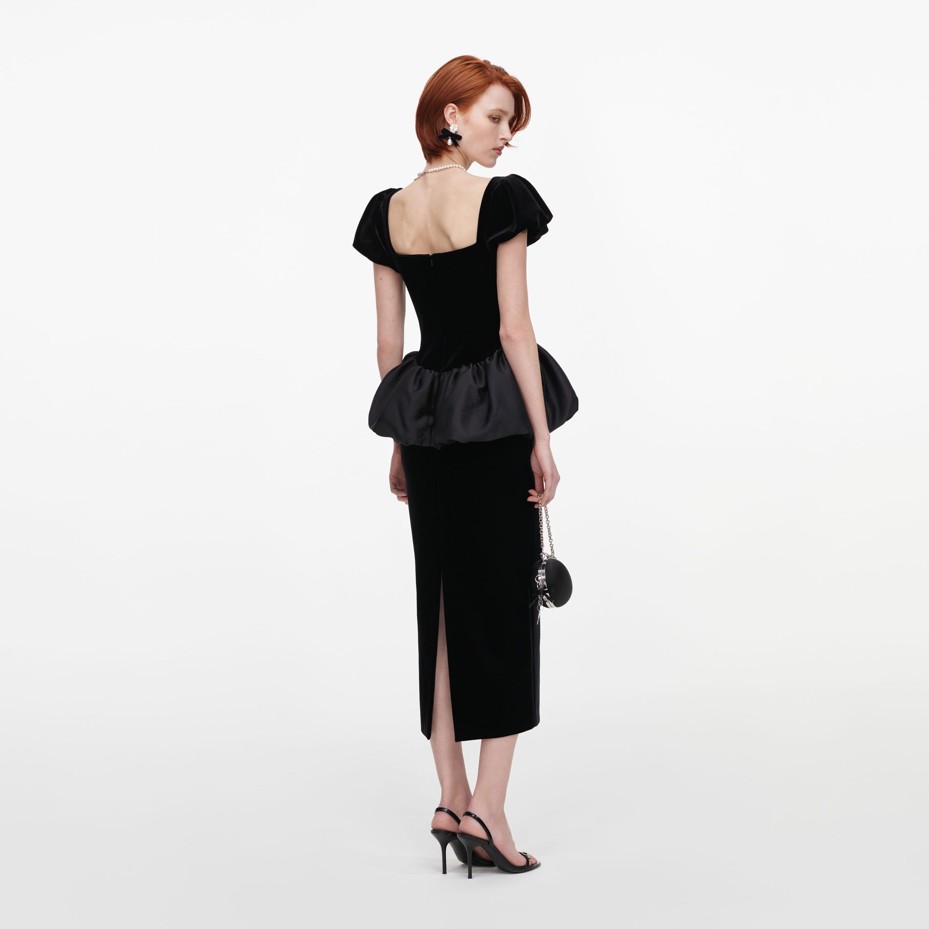 Back view of a woman wearing the Black Velvet Bubble Peplum Midi Dress