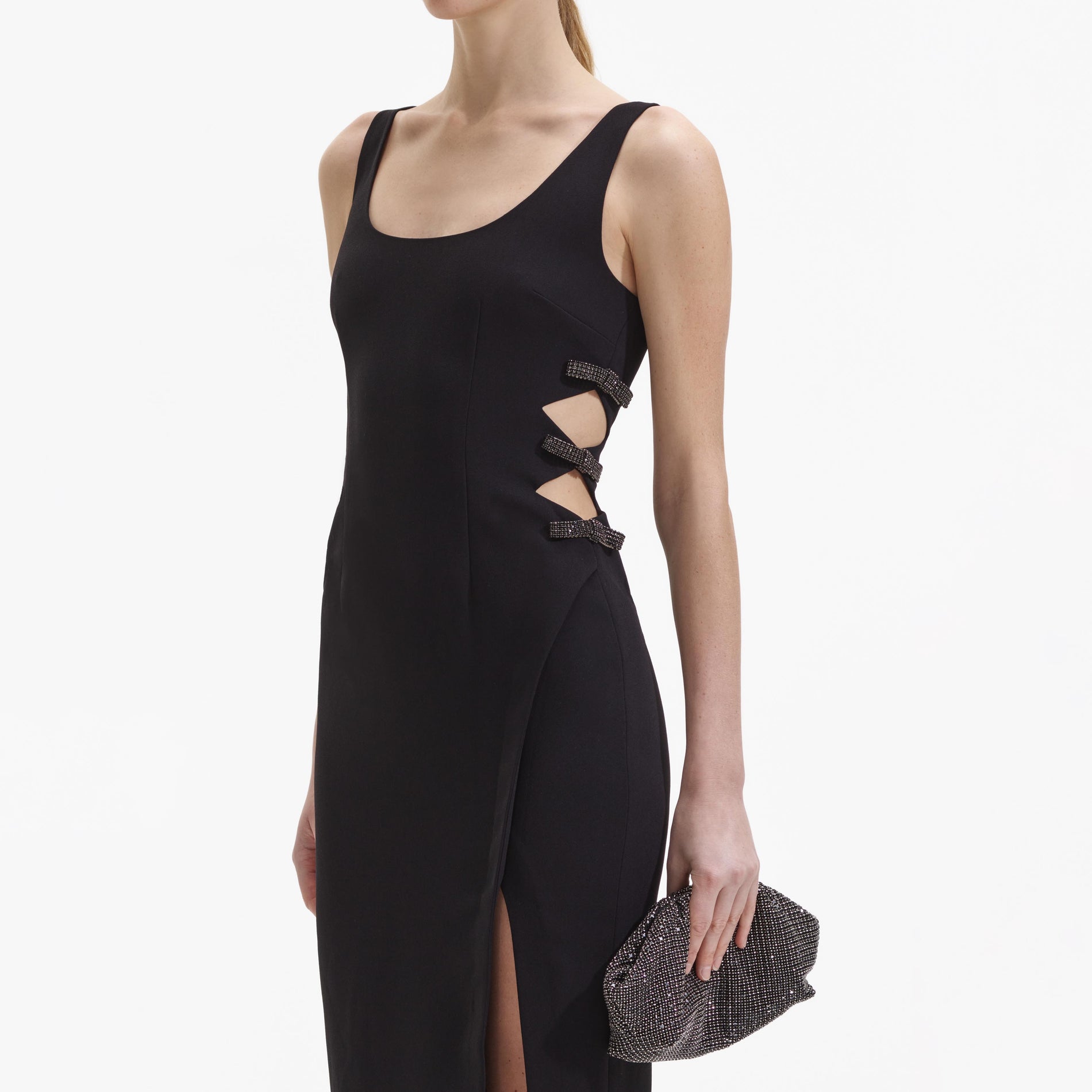 A close up of a woman wearing the Black Crepe Bow Midi Dress