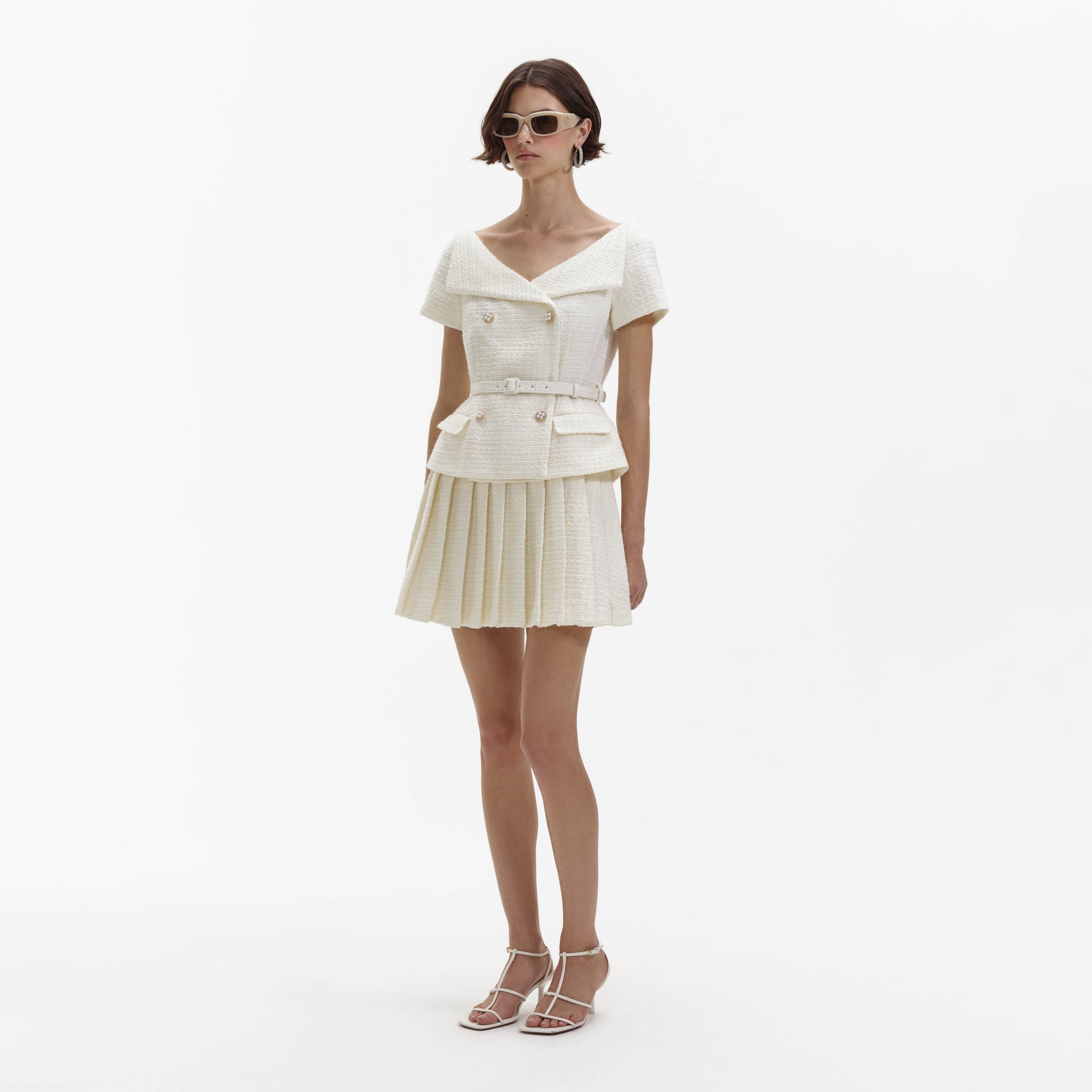 Side view of a woman wearing the Cream Boucle Pleated Mini Dress
