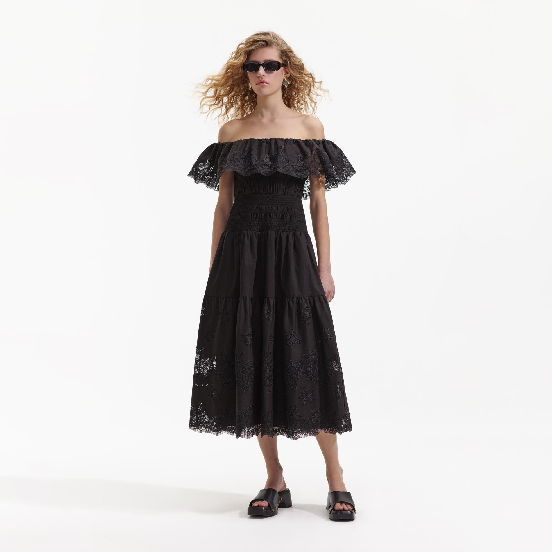 Side view of a woman wearing the Black Cotton Midi Dress