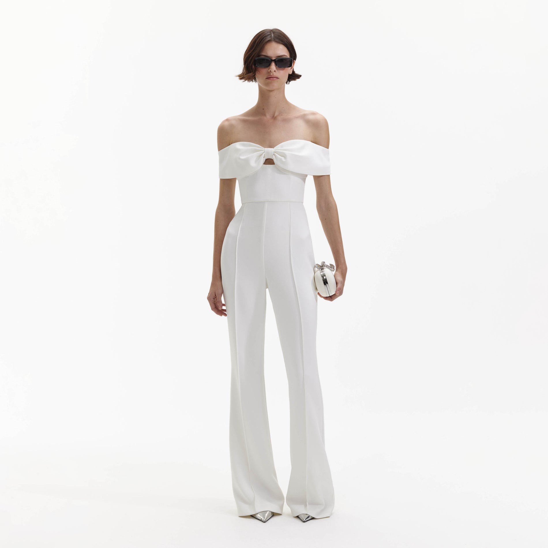 Front view of a woman wearing the White Crepe Bow Jumpsuit