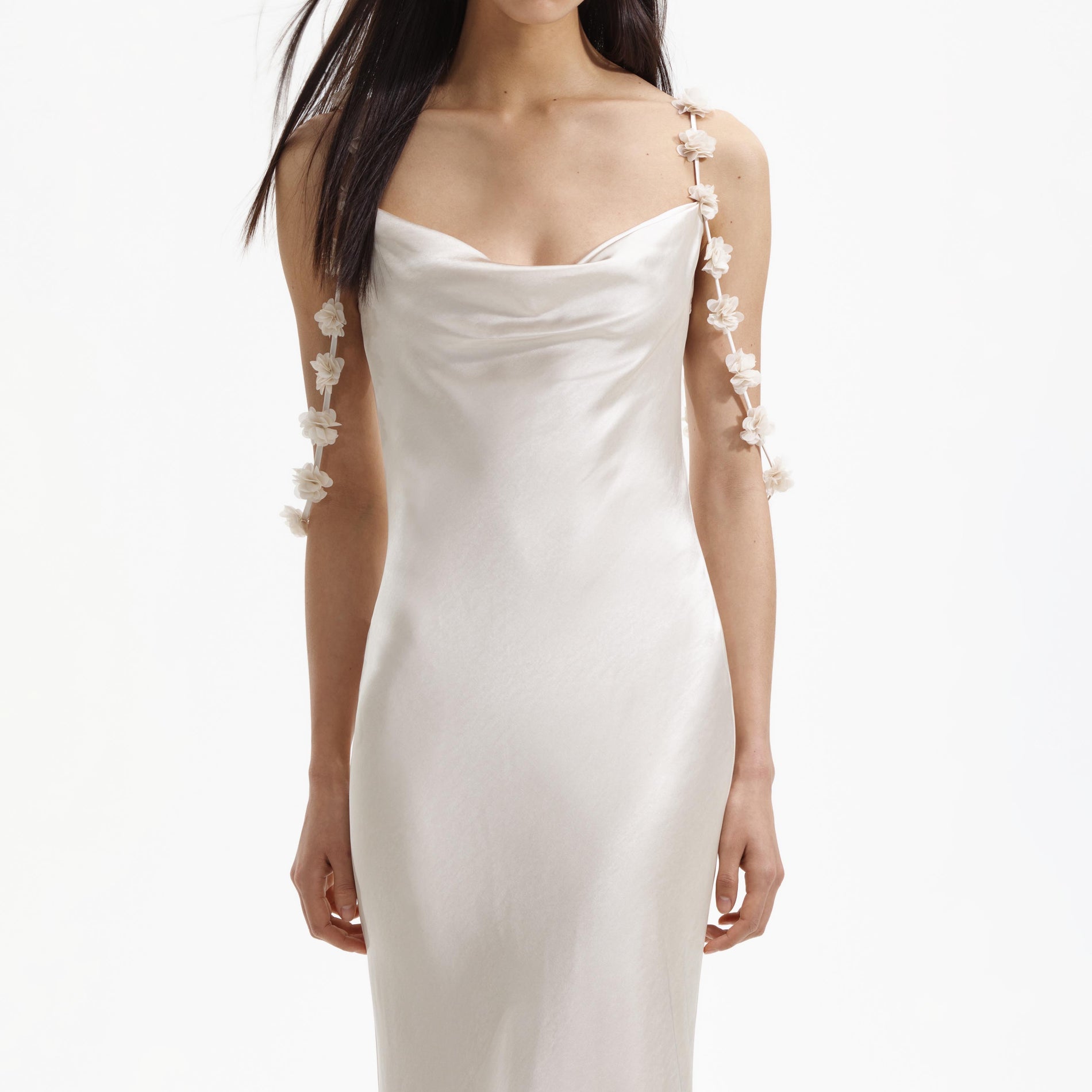 A close up of a woman wearing the Champagne Satin Flower Maxi Dress