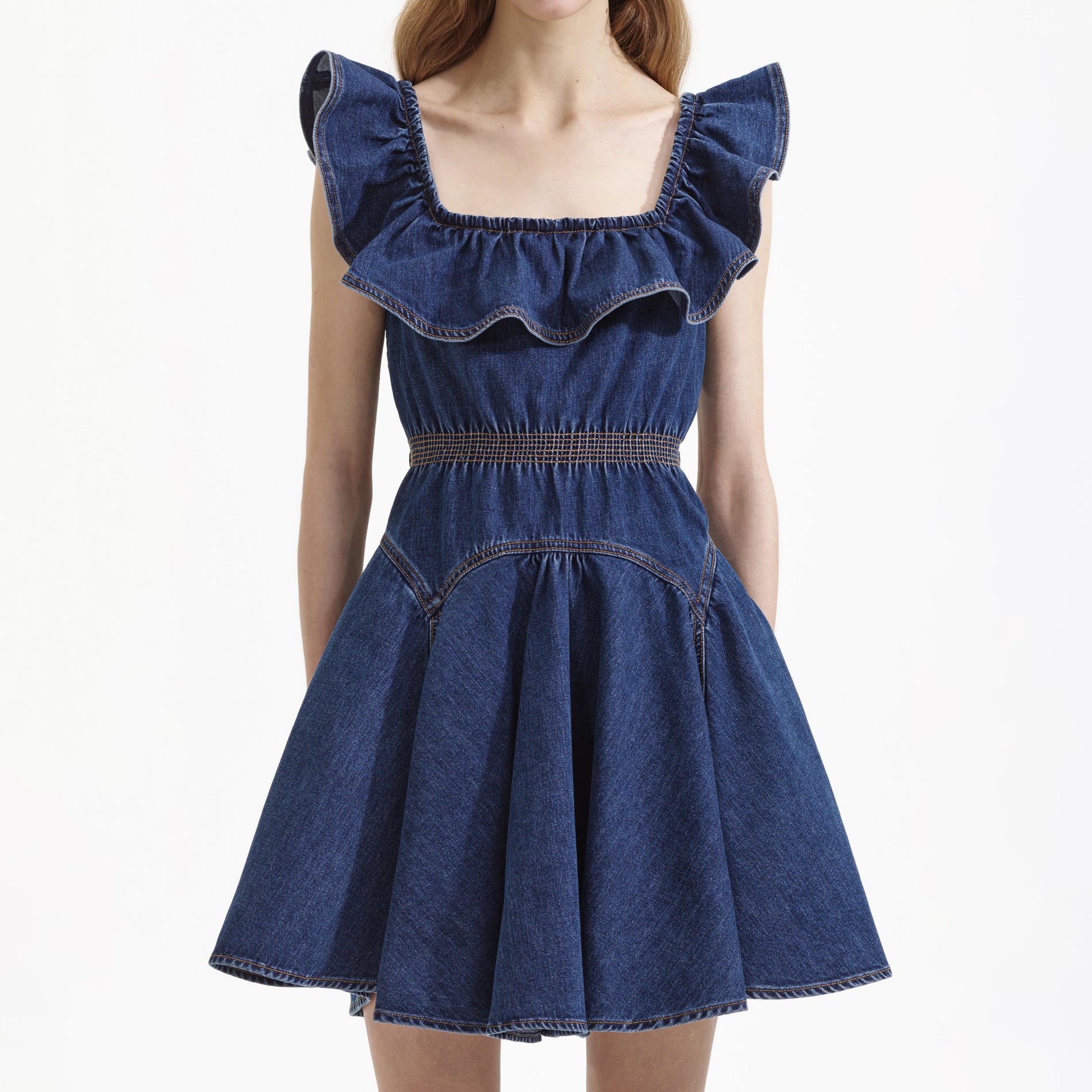 A close up of a woman wearing the Denim Ruffle Mini Dress