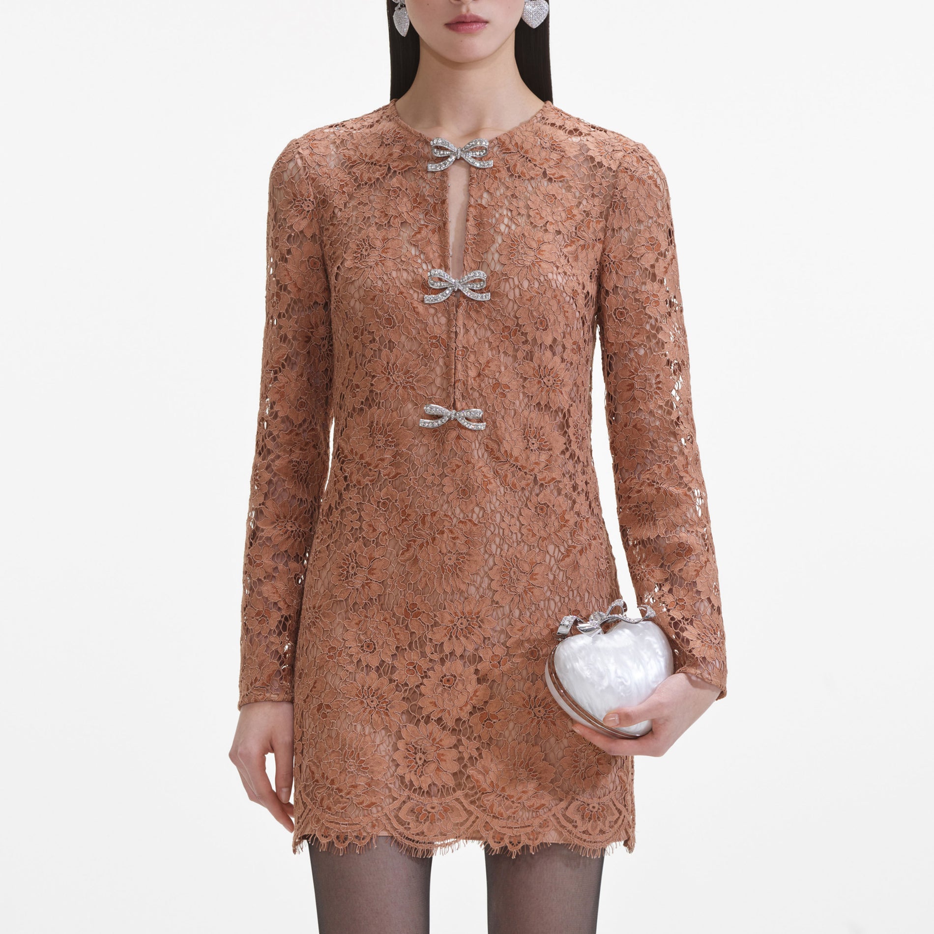 A close up of a woman wearing the Tan Lace Bow Mini Dress