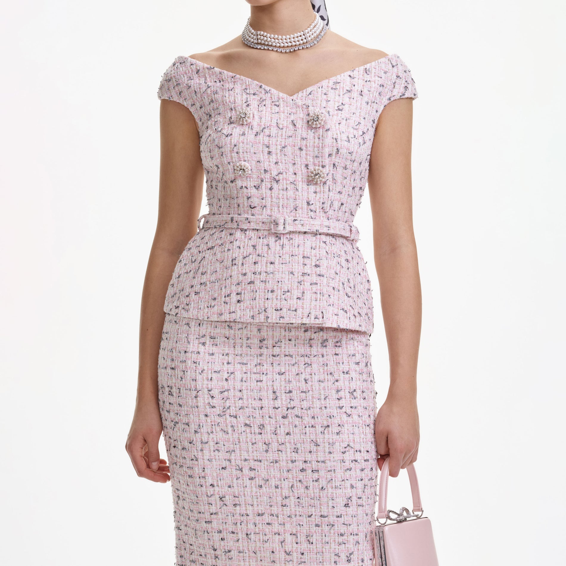 A close up of a woman wearing the Pink Boucle Pearl Midi Dress