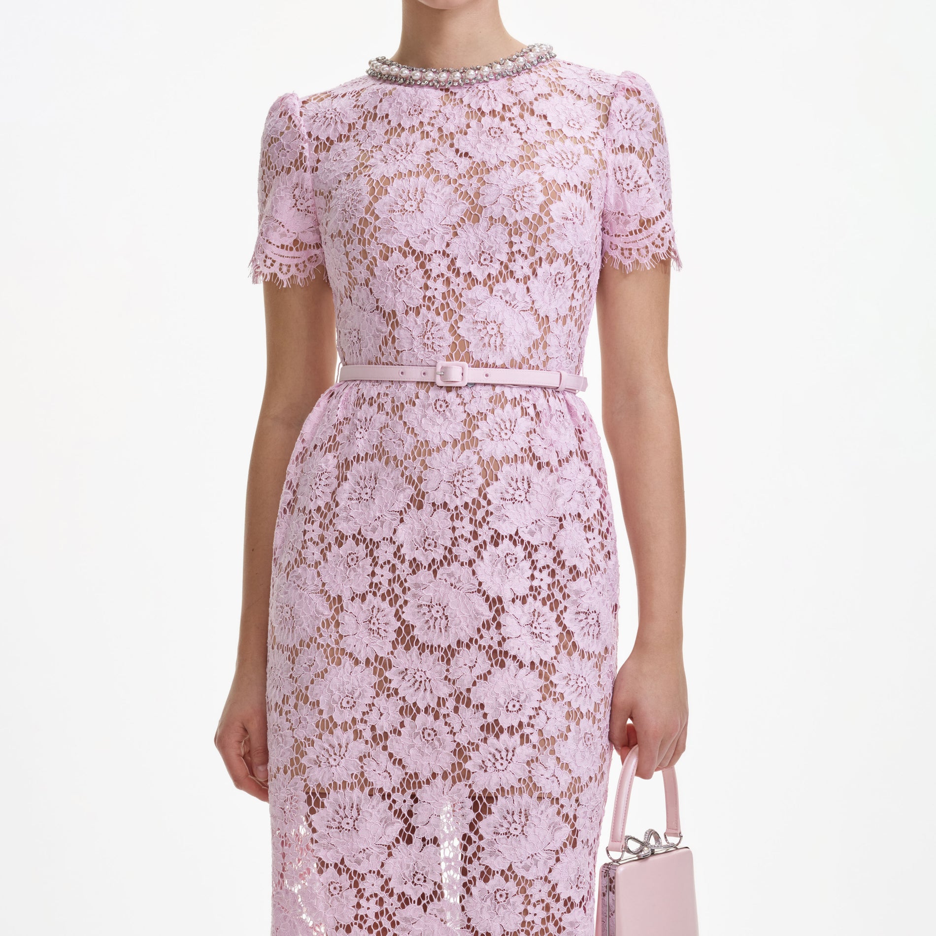 A close up of a woman wearing the Pink Fine Lace Pearl Midi Dress