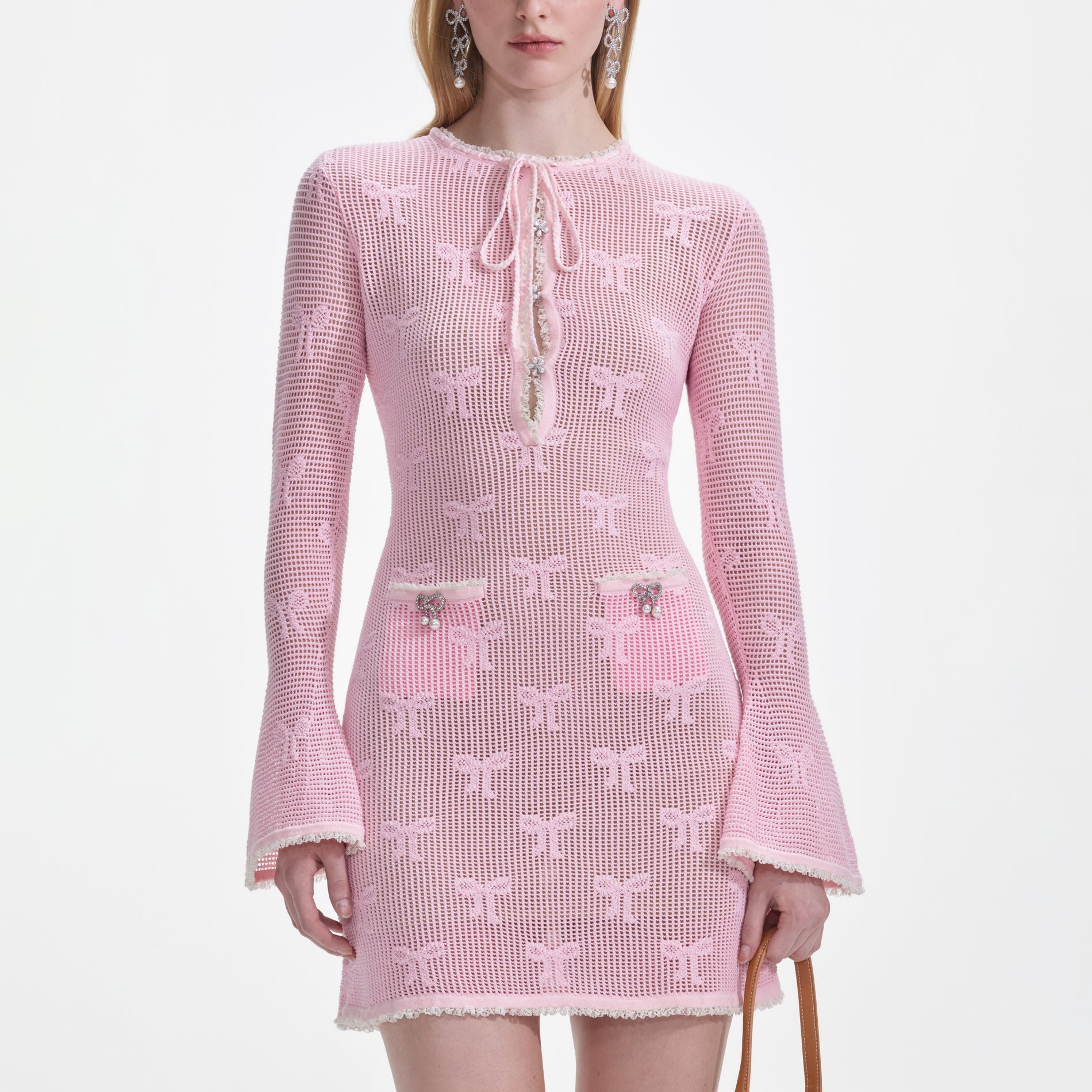 A close up of a woman wearing the Pink Bow Crochet Mini Dress