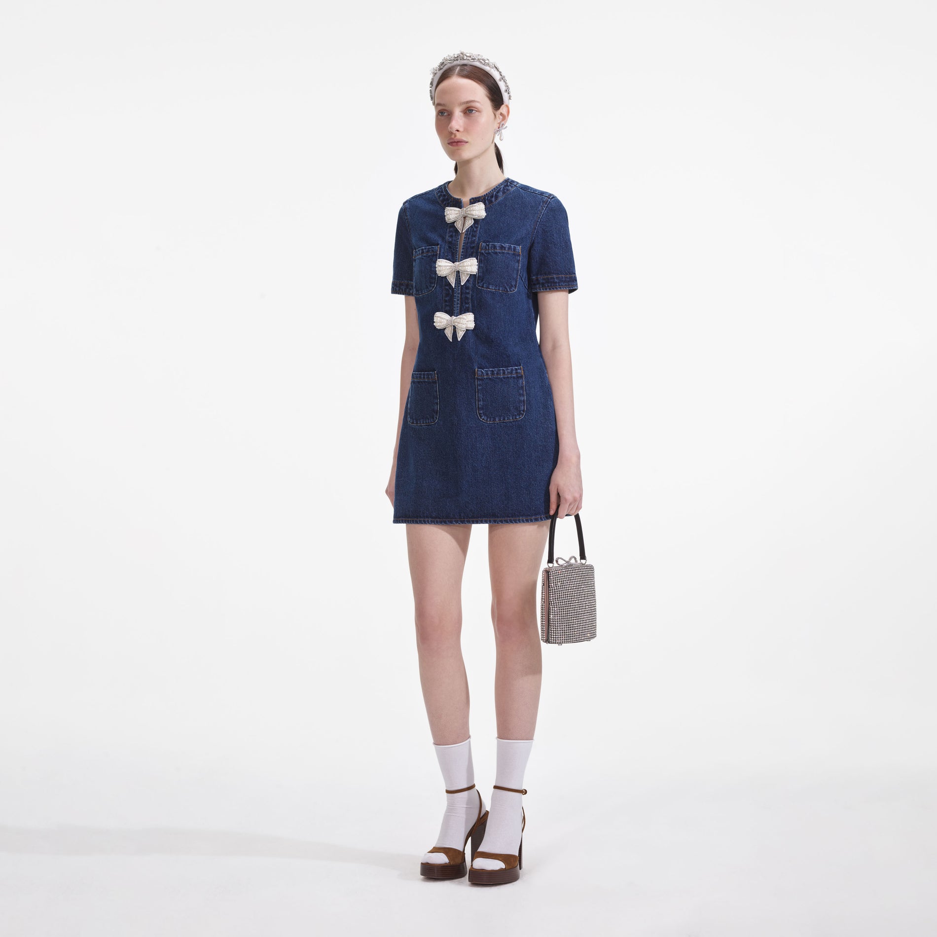 Side view of a woman wearing the Denim Bow Mini Dress