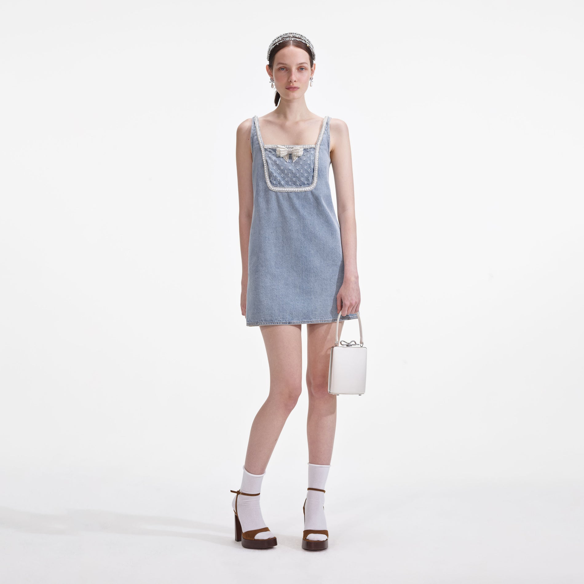 Front view of a woman wearing the Light Blue Denim Bow Mini Dress