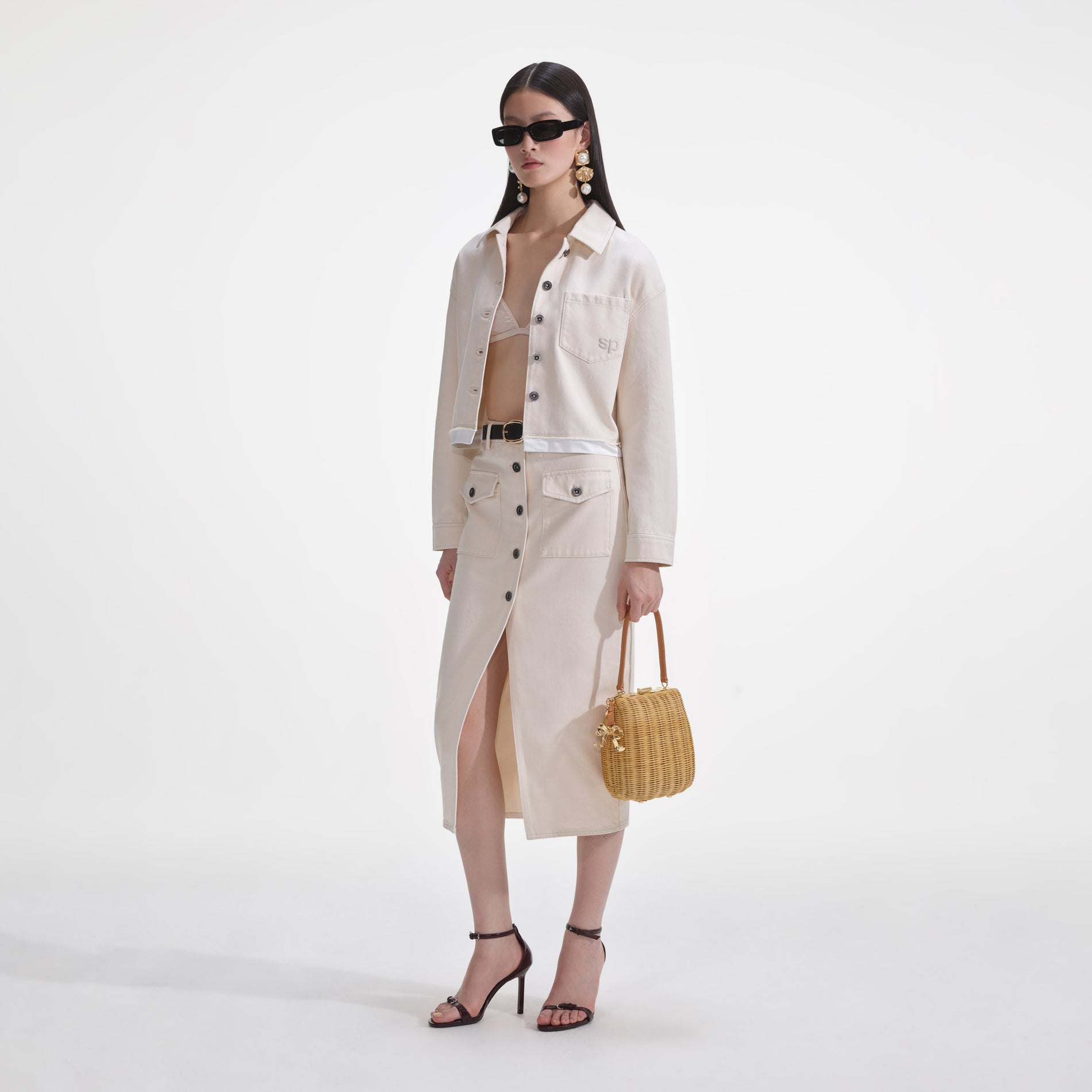 Side view of a woman wearing the Cream Denim Midi Skirt