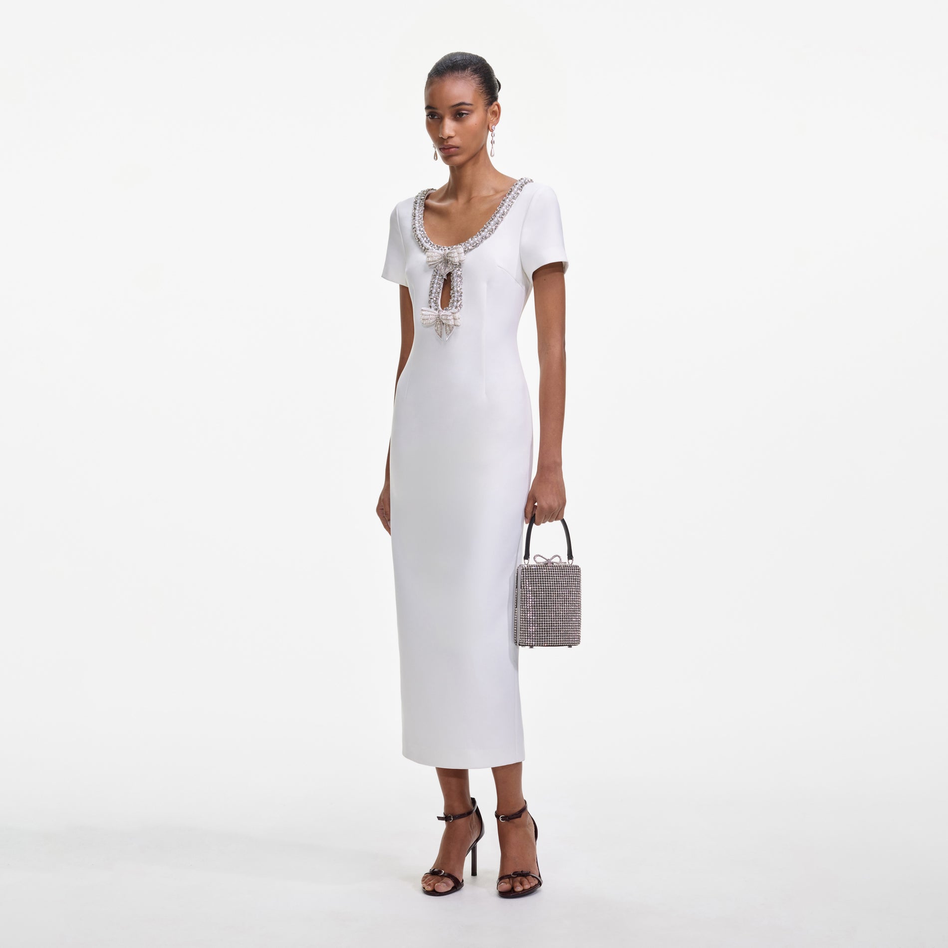 Side view of a woman wearing the White Crepe Bow Midi Dress