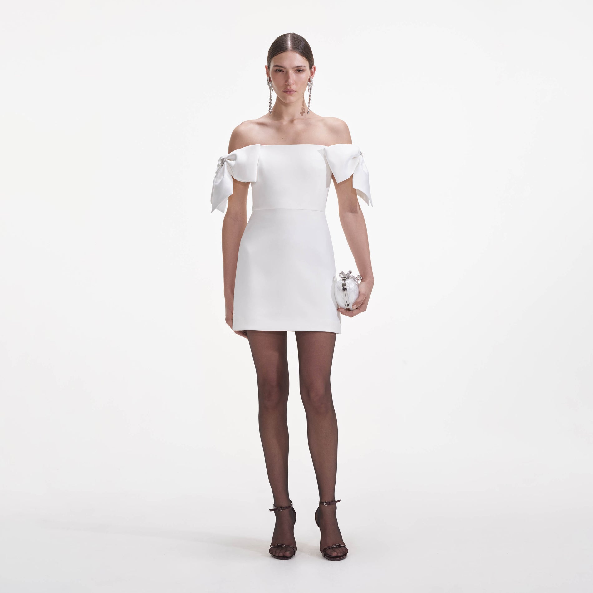 Front view of a woman wearing the White Crepe Bow Mini Dress