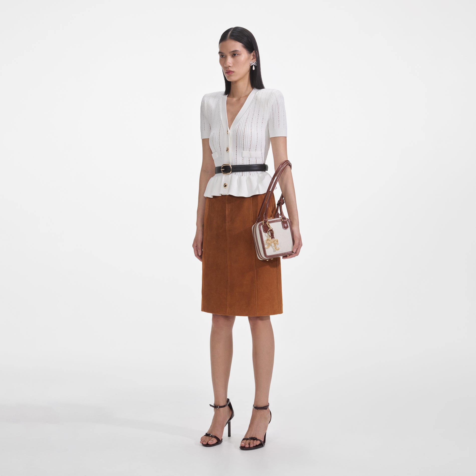 Side view of a woman wearing the White Peplum Knit Top