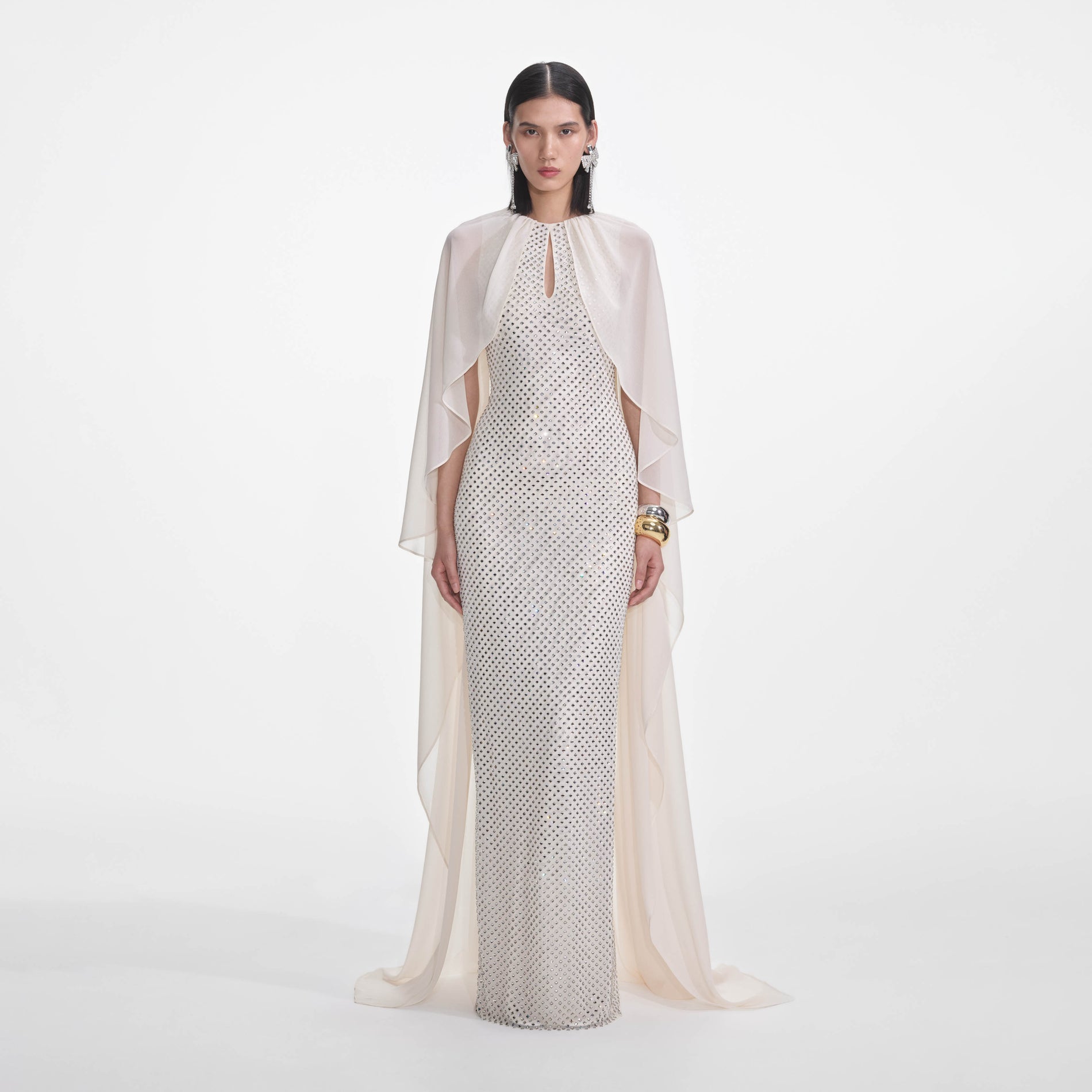 Front view of a woman wearing the Cream Rhinestone Cape Maxi Dress