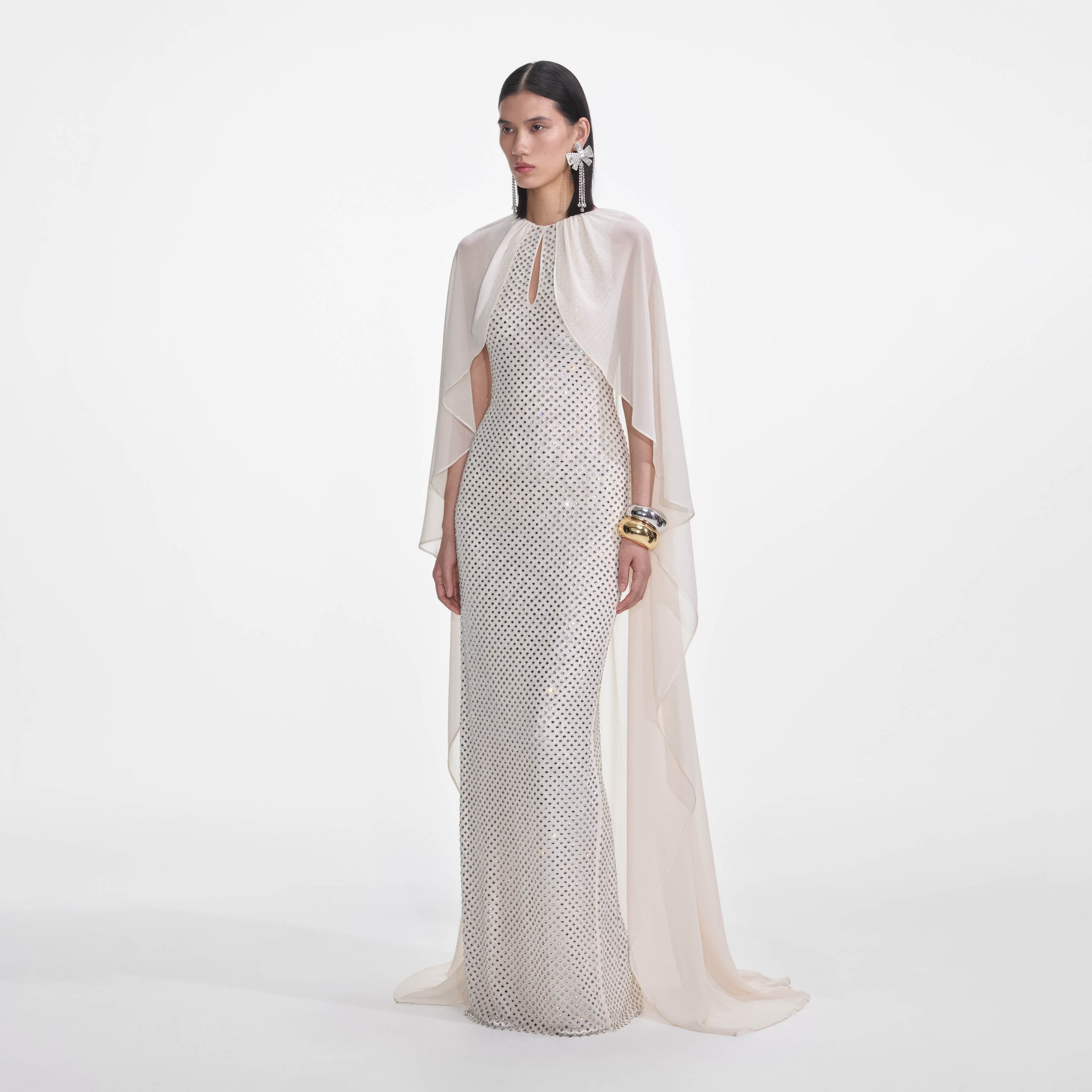 Side view of a woman wearing the Cream Rhinestone Cape Maxi Dress