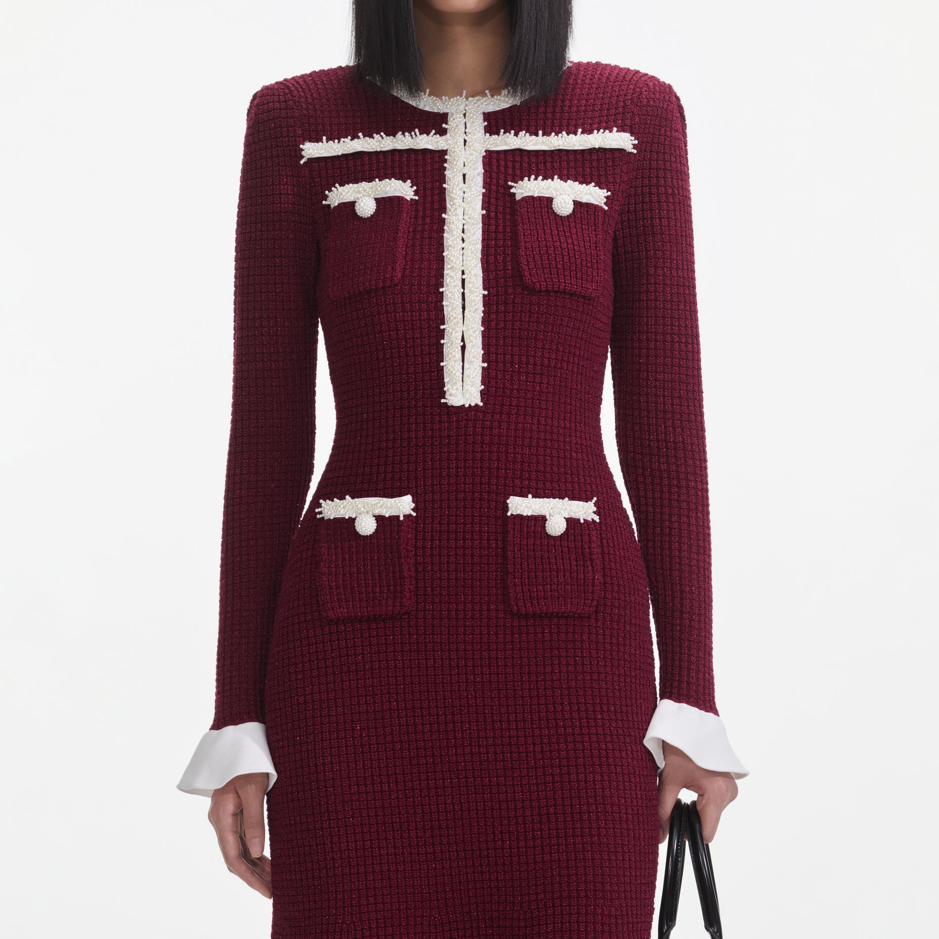 A close up of a woman wearing the Burgundy Pearl Trim Knit Midi Dress