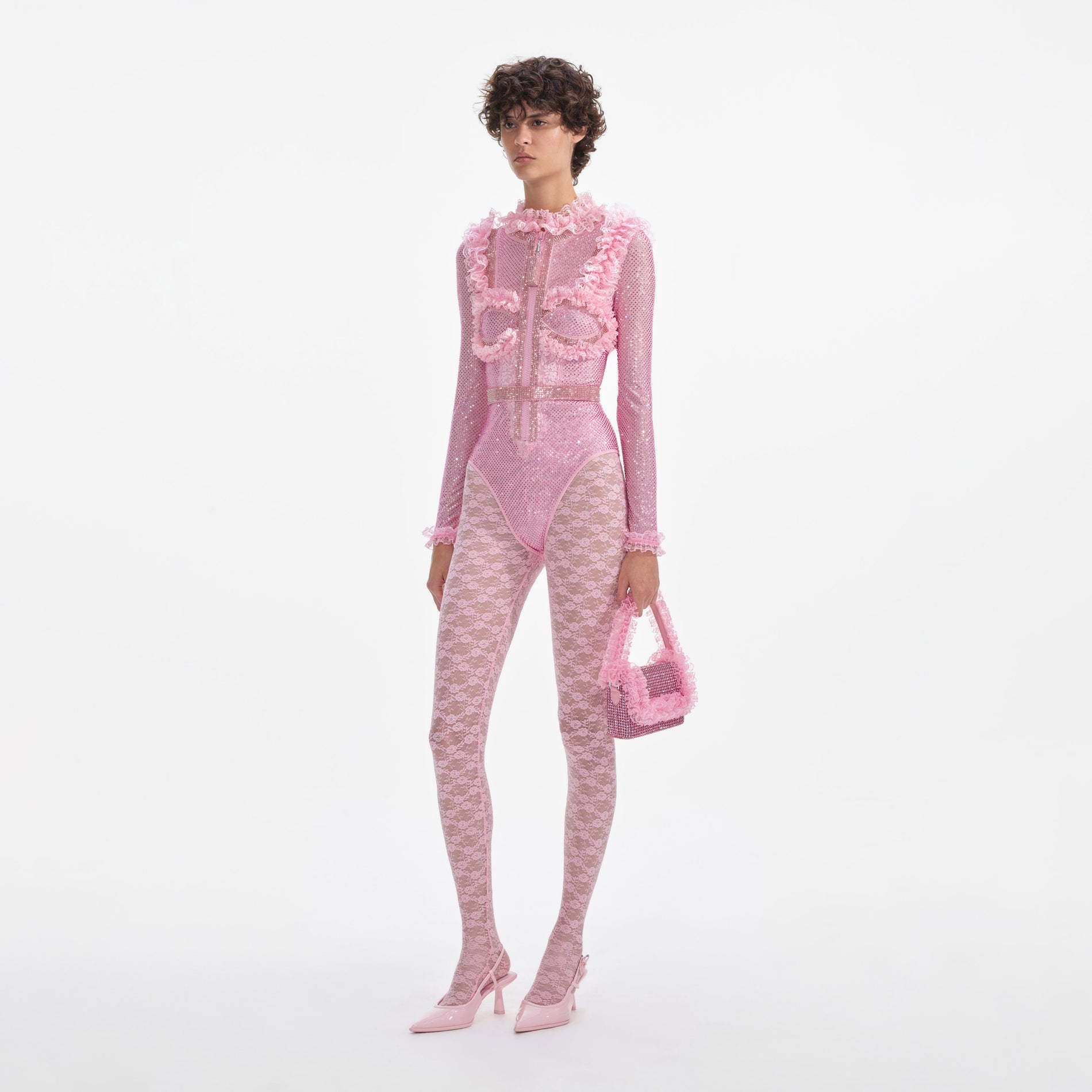 Side view of a woman wearing the Pink Rhinestone Mesh Ruffle Bodysuit