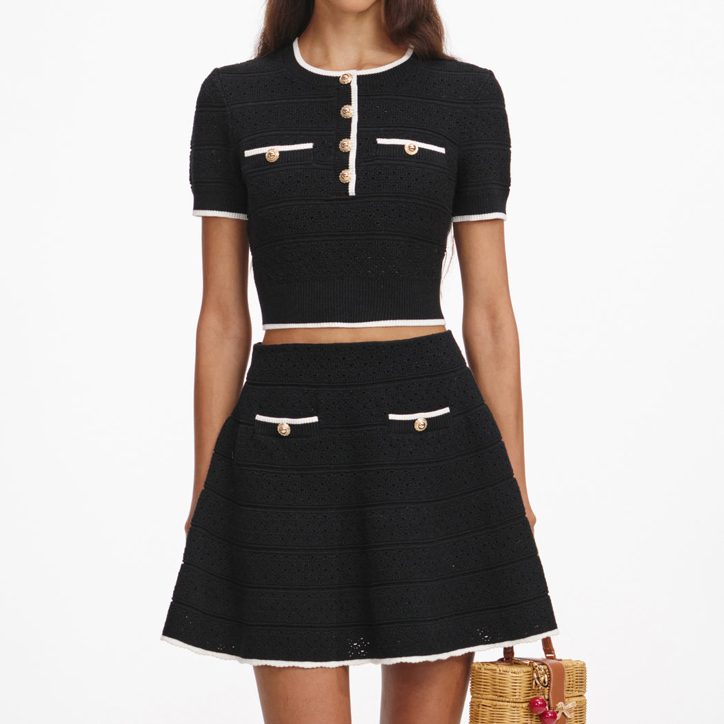 A close up of a woman wearing the Black Pointelle Knit Mini Skirt