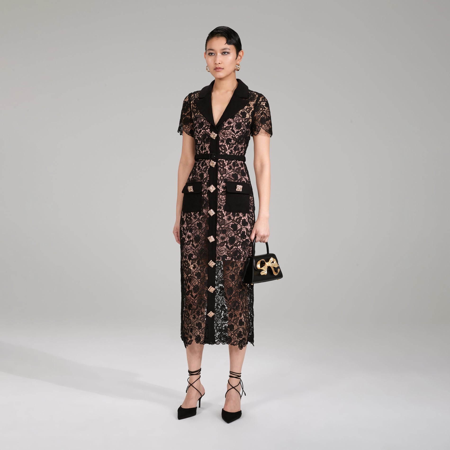 A woman wearing the Black Magnolia Lace Midi Dress