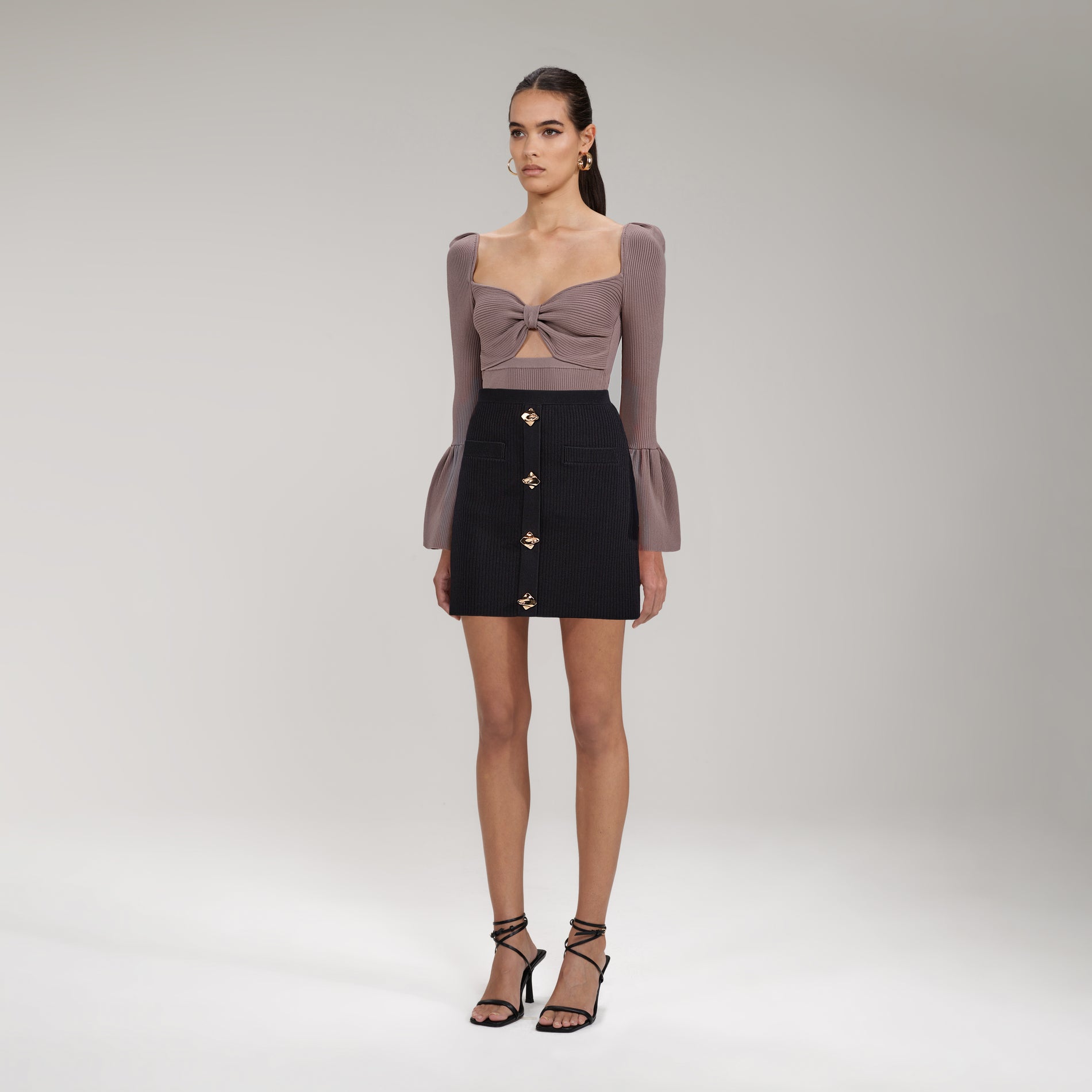 A woman wearing the Taupe Ribbed Knit Bow Bust Top