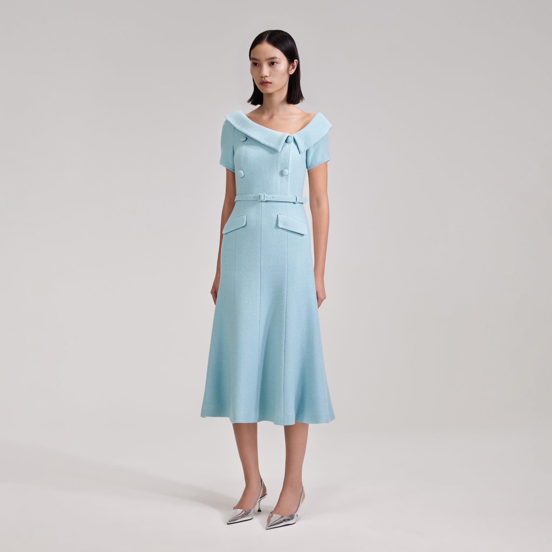 A woman wearing the Blue Textured Woven Midi Dress