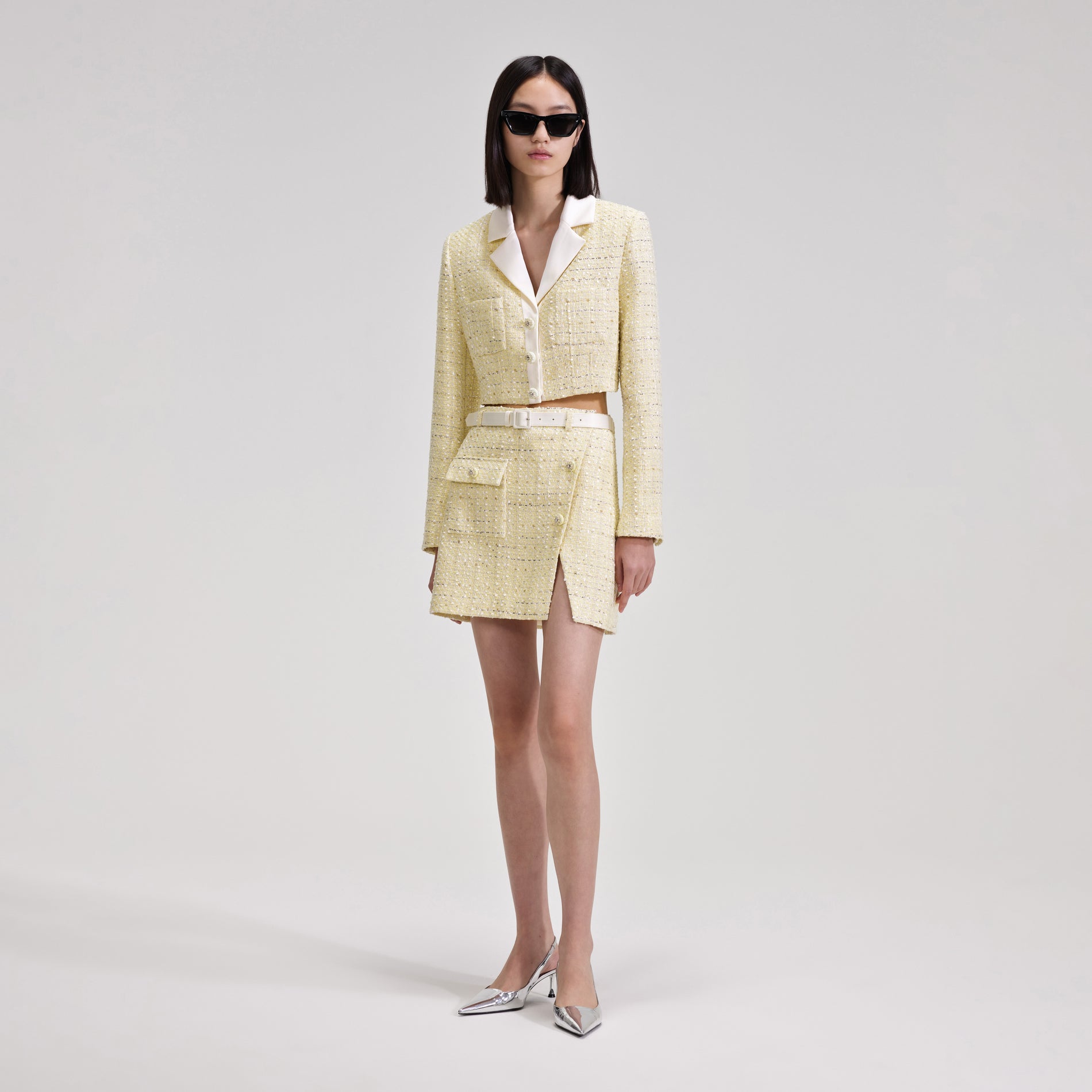 A woman wearing the Yellow Boucle Mini Skirt