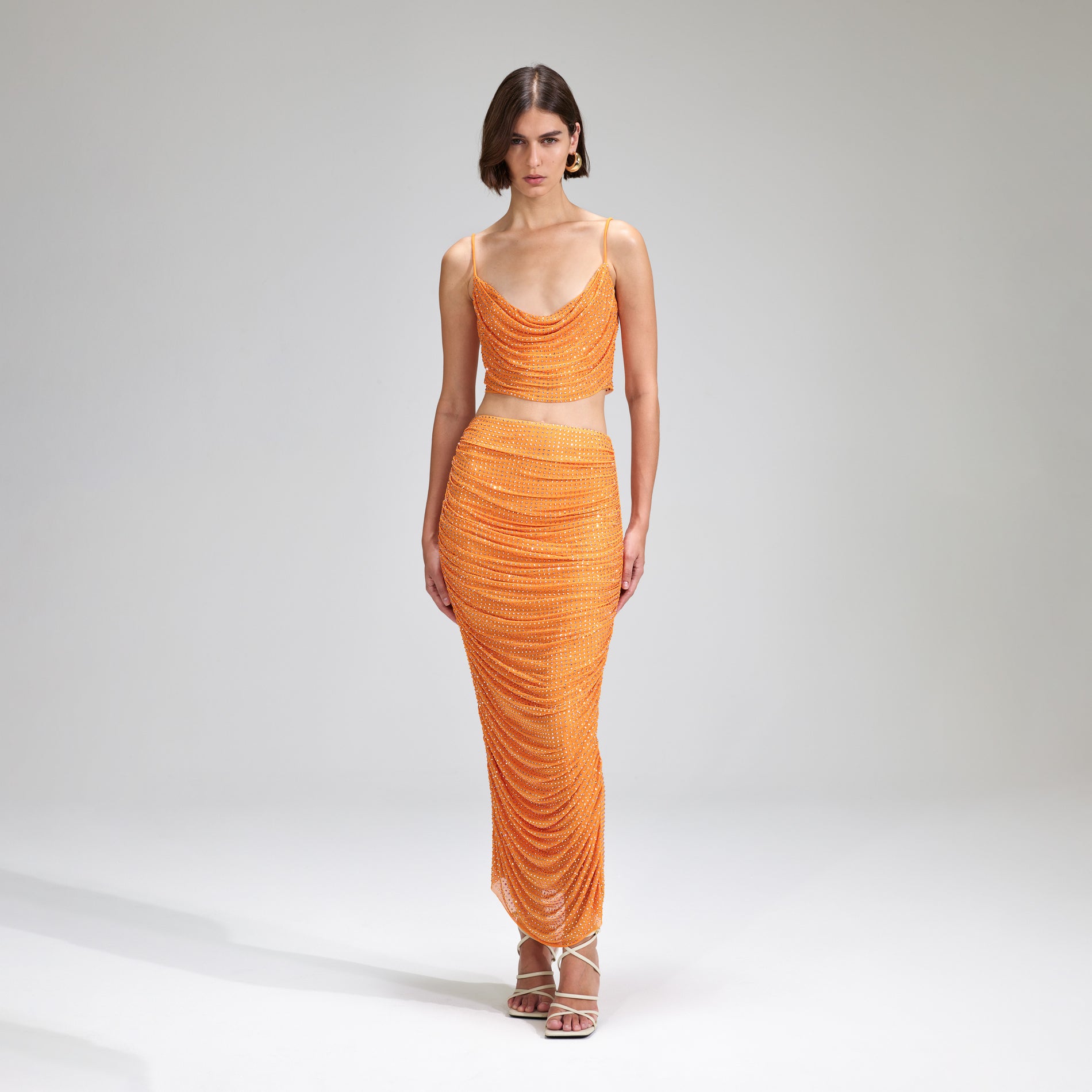 A woman wearing the Orange Rhinestone Mesh Top