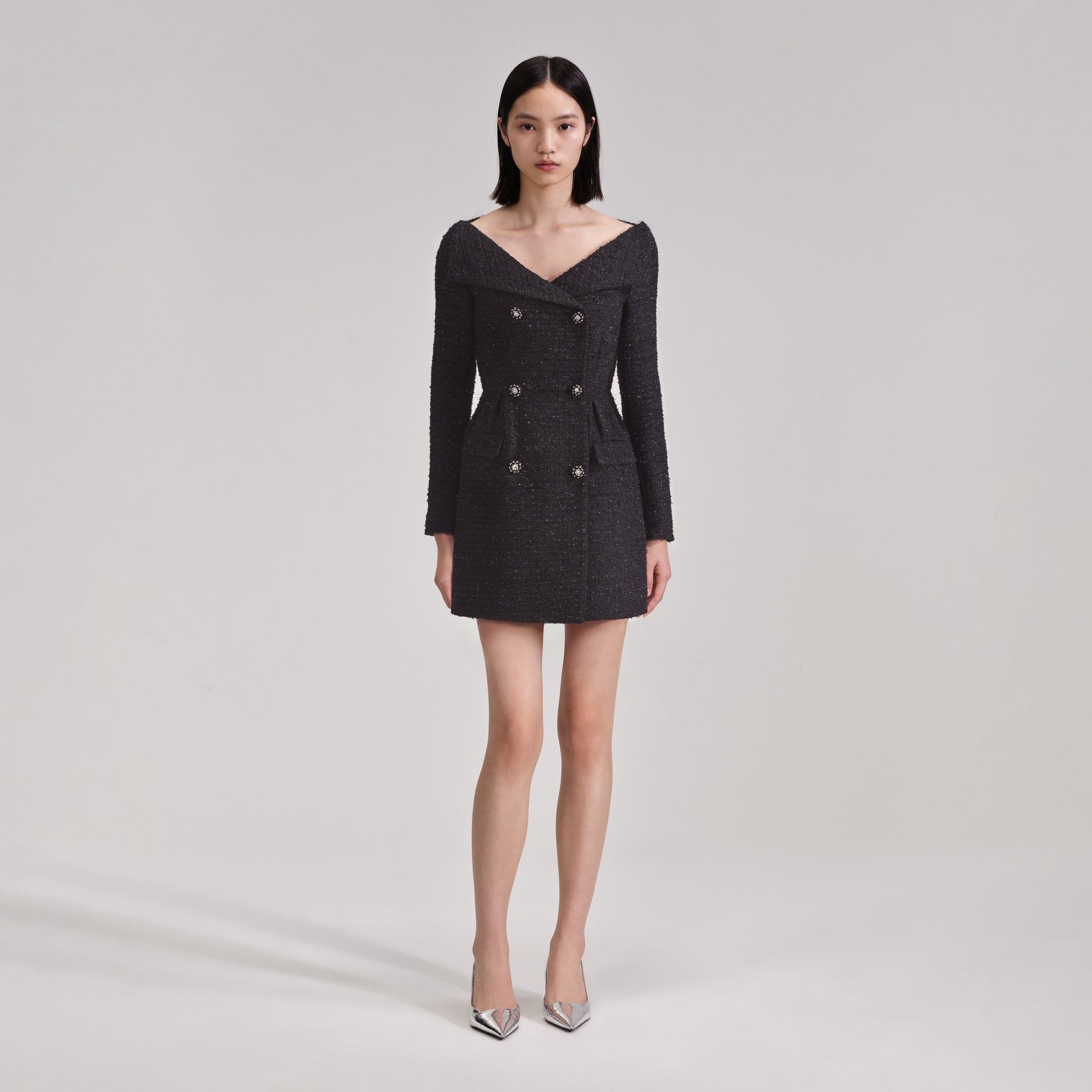 A woman wearing the Black Off Shoulder Boucle Mini Dress