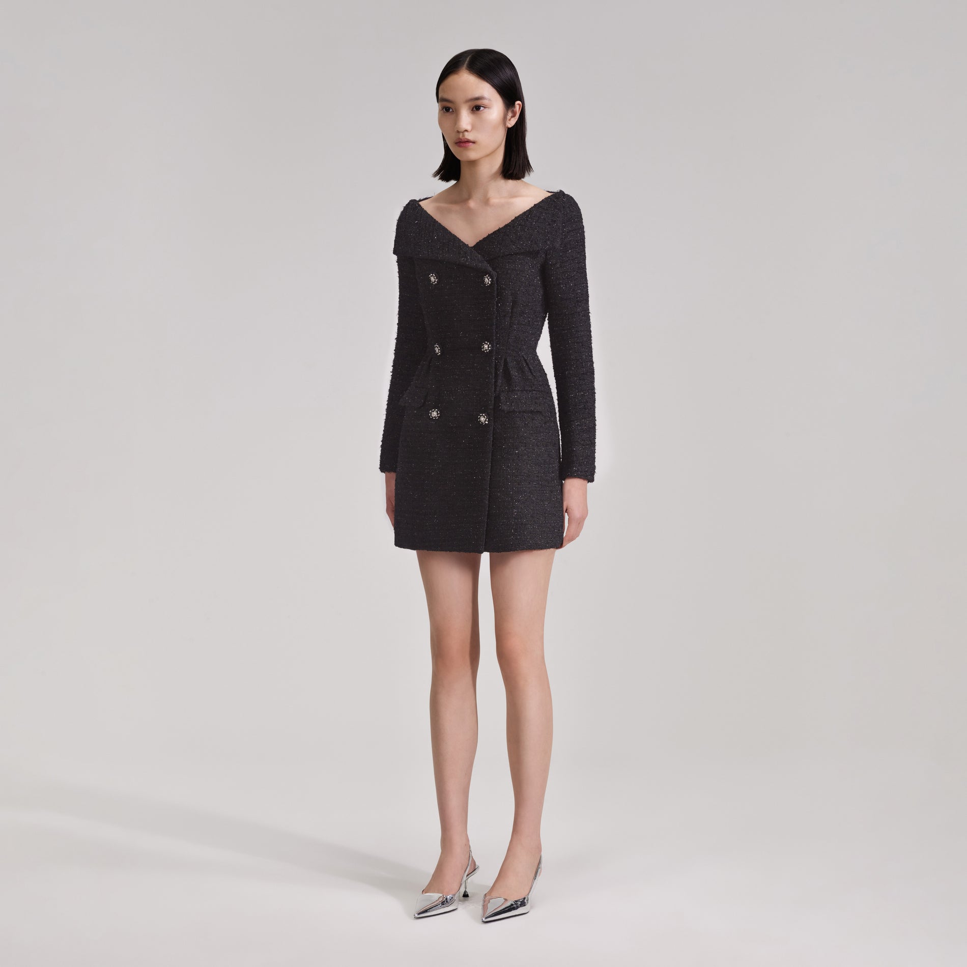 A woman wearing the Black Off Shoulder Boucle Mini Dress