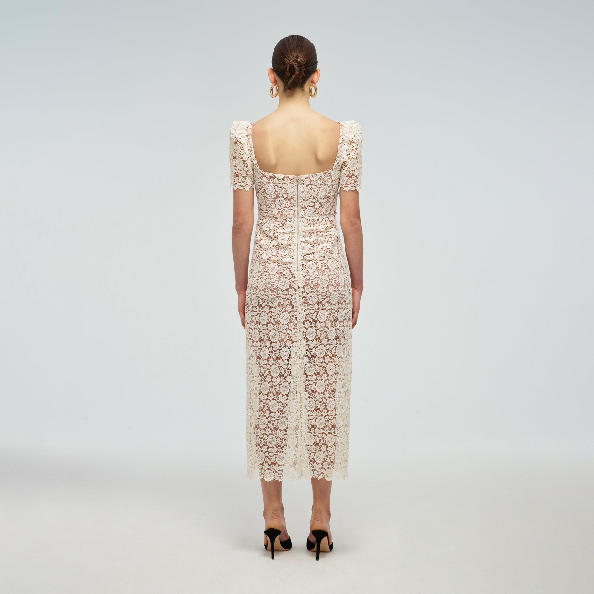 A woman wearing the Ivory Guipure Fitted Midi Dress