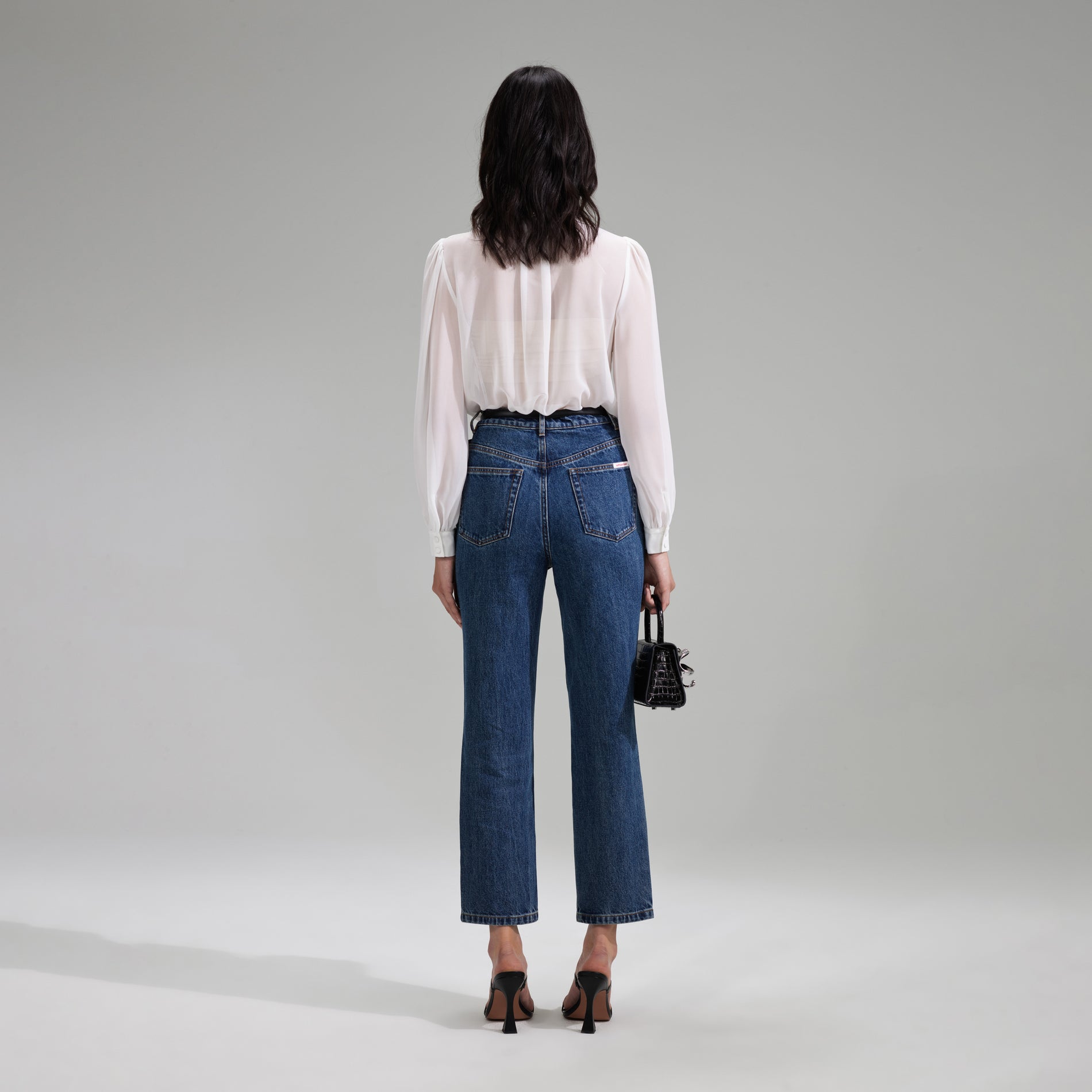 A woman wearing the White Chiffon Rhinestone Detail Top