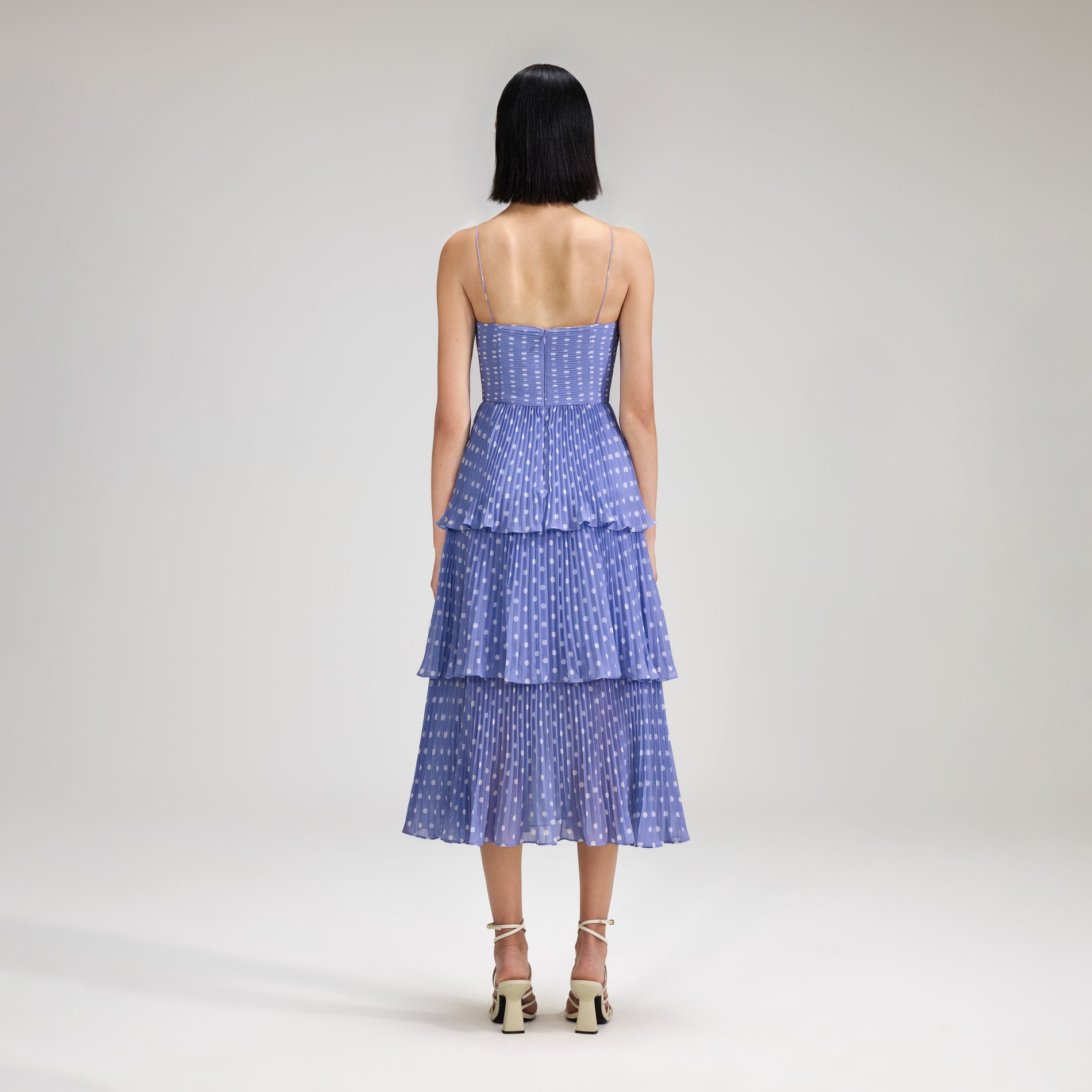 A woman wearing the Lilac Polka Dot Tiered Chiffon Midi Dress