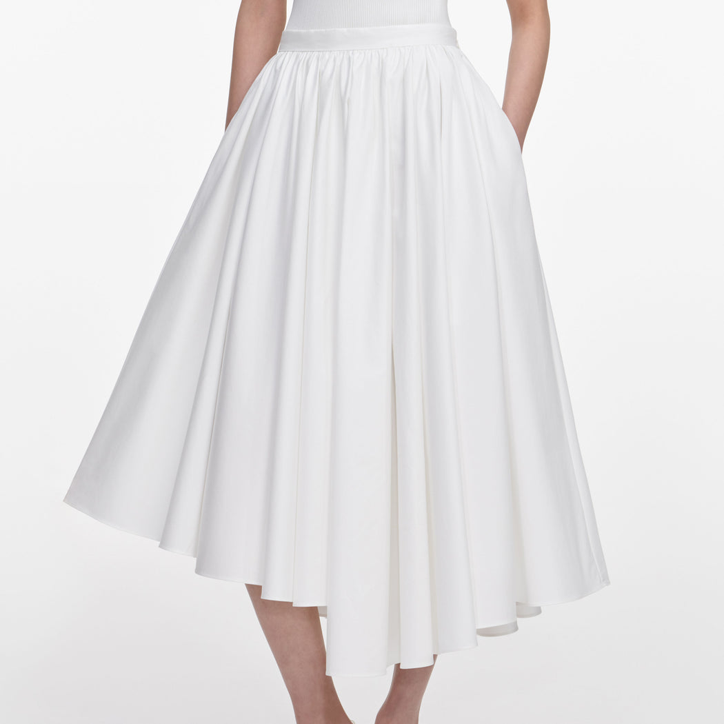 A close up of a woman wearing the White Cotton Poplin Midi Skirt