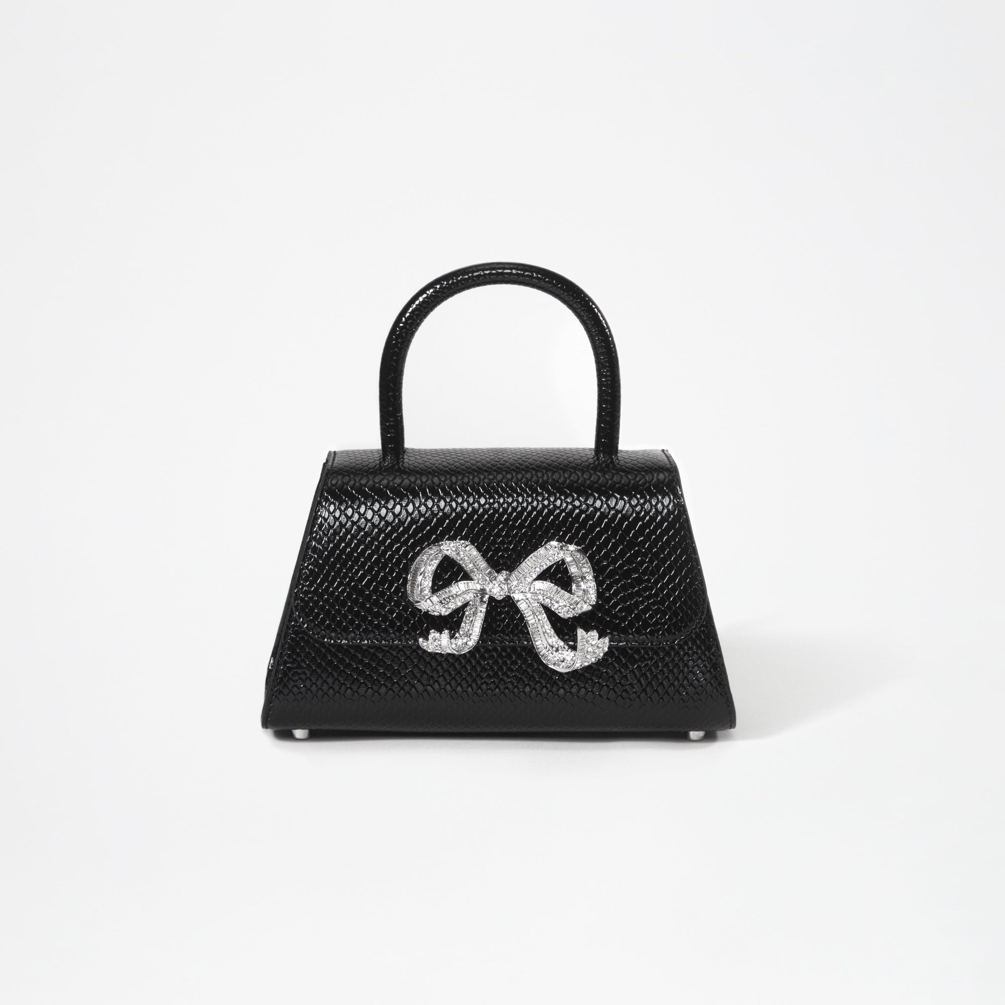 A woman wearing the Black Python Diamante Bow Mini Bag