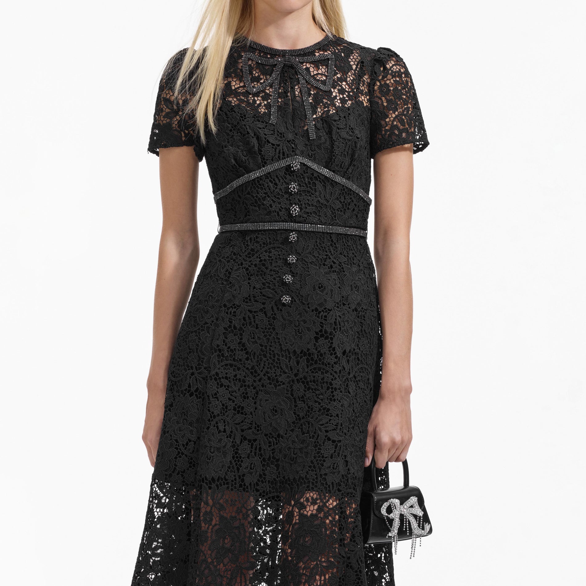 A close up of a woman wearing the Black Cord Lace Bow Midi Dress