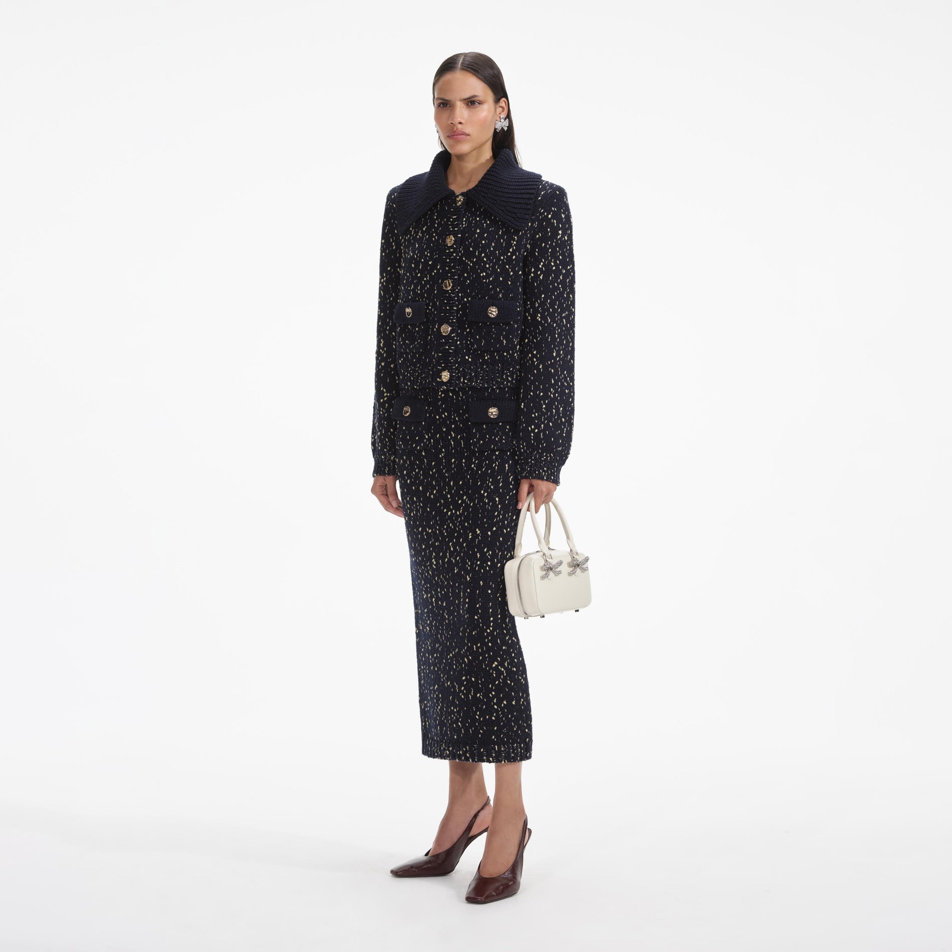 Side view of a woman wearing the Navy Metallic Merino Knit Midi Skirt