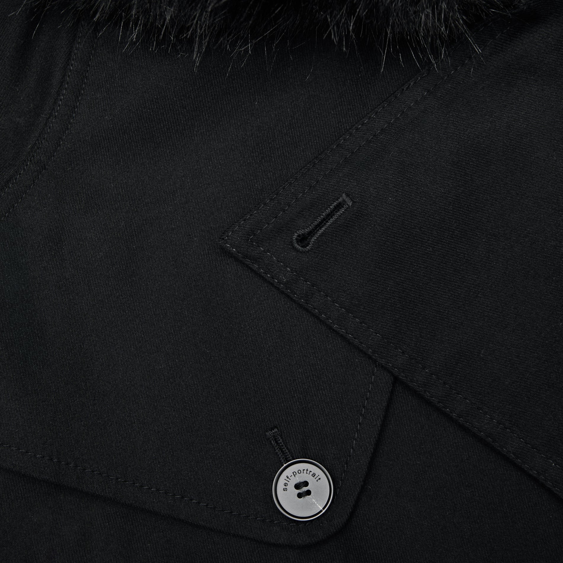 A close up of the fabric for the Black Twill Fur Collar Trench Coat