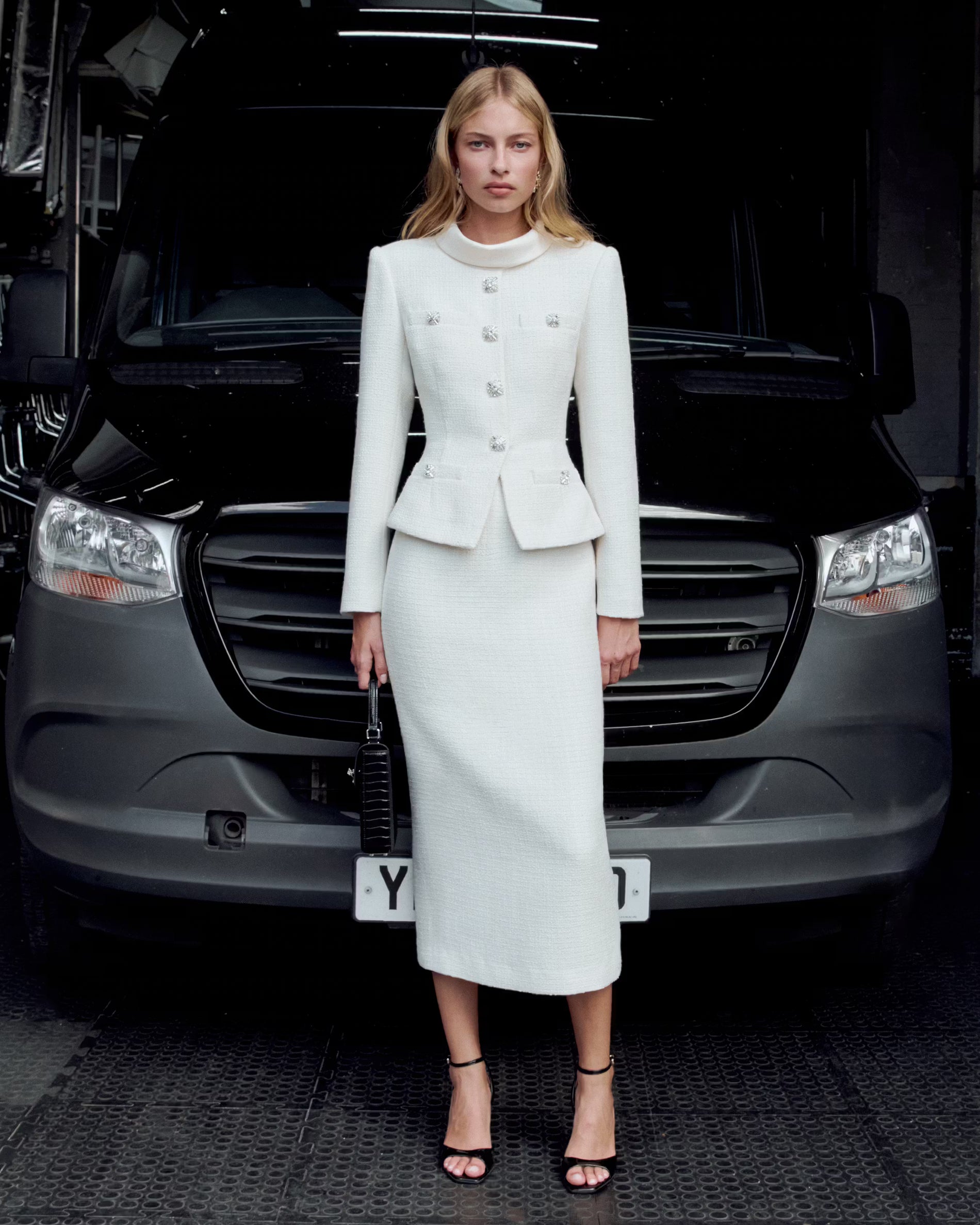 A lifestyle image of a woman wearing the Cream Boucle Tailored Midi Dress