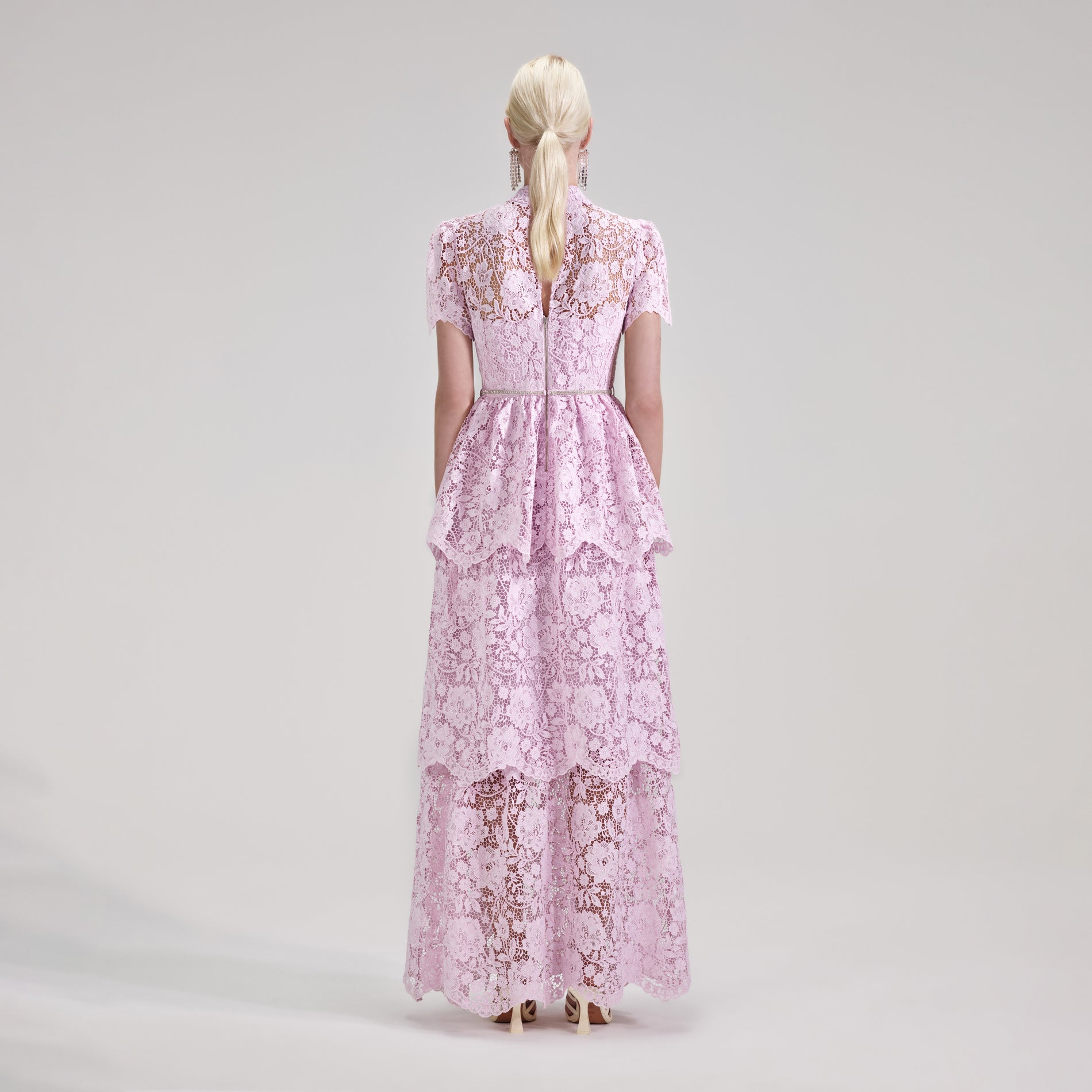 A woman wearing the Pink Cord Lace Tiered Maxi Dress