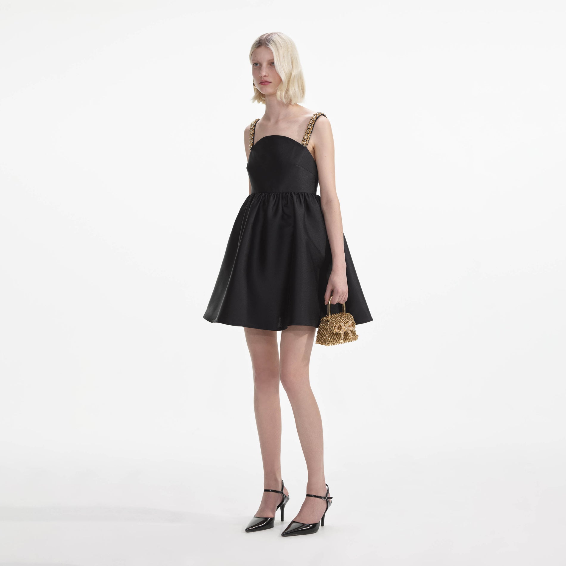 Side view of a woman wearing the Black Taffeta Embellished Mini Dress