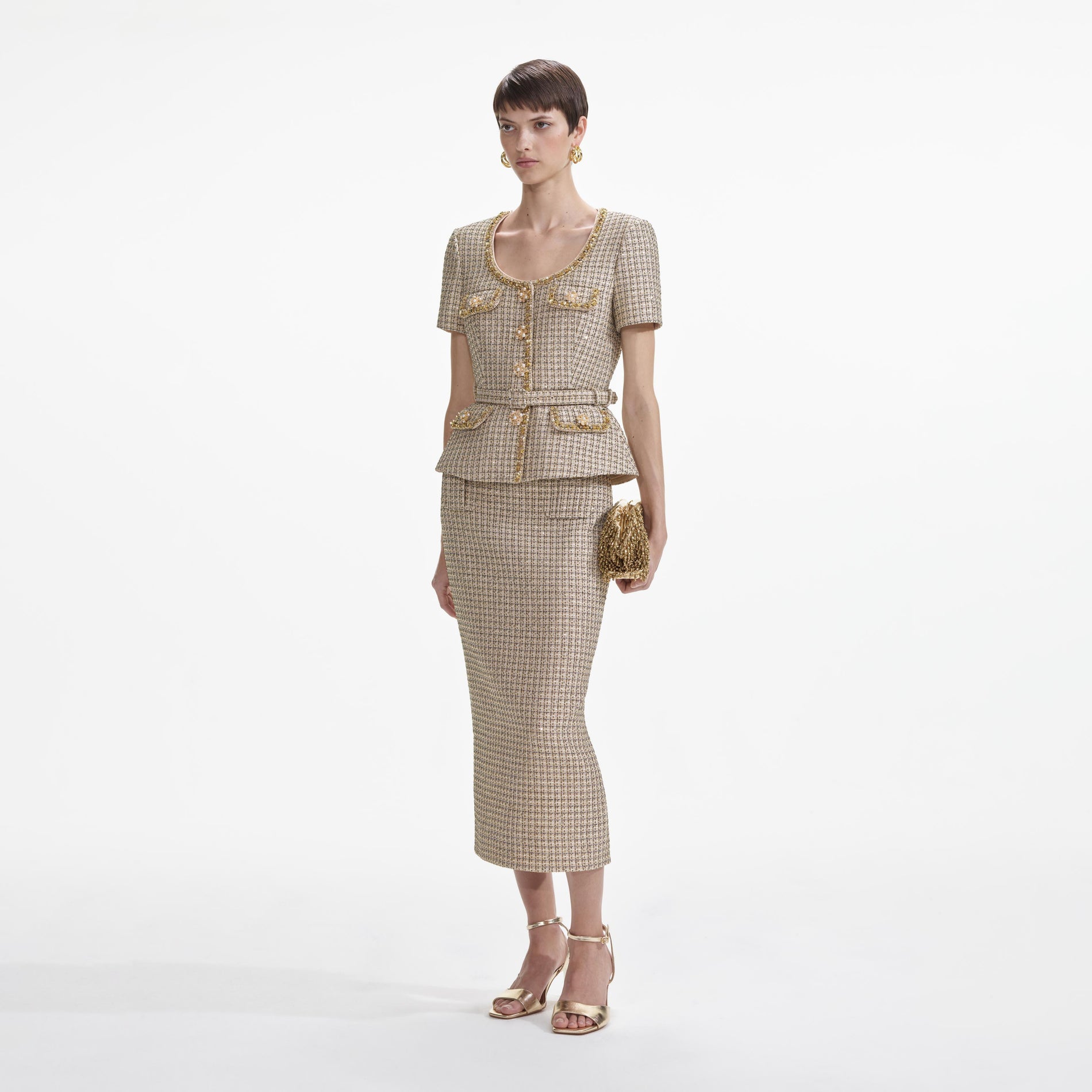 Side view of a woman wearing the Gold Boucle Peplum Top