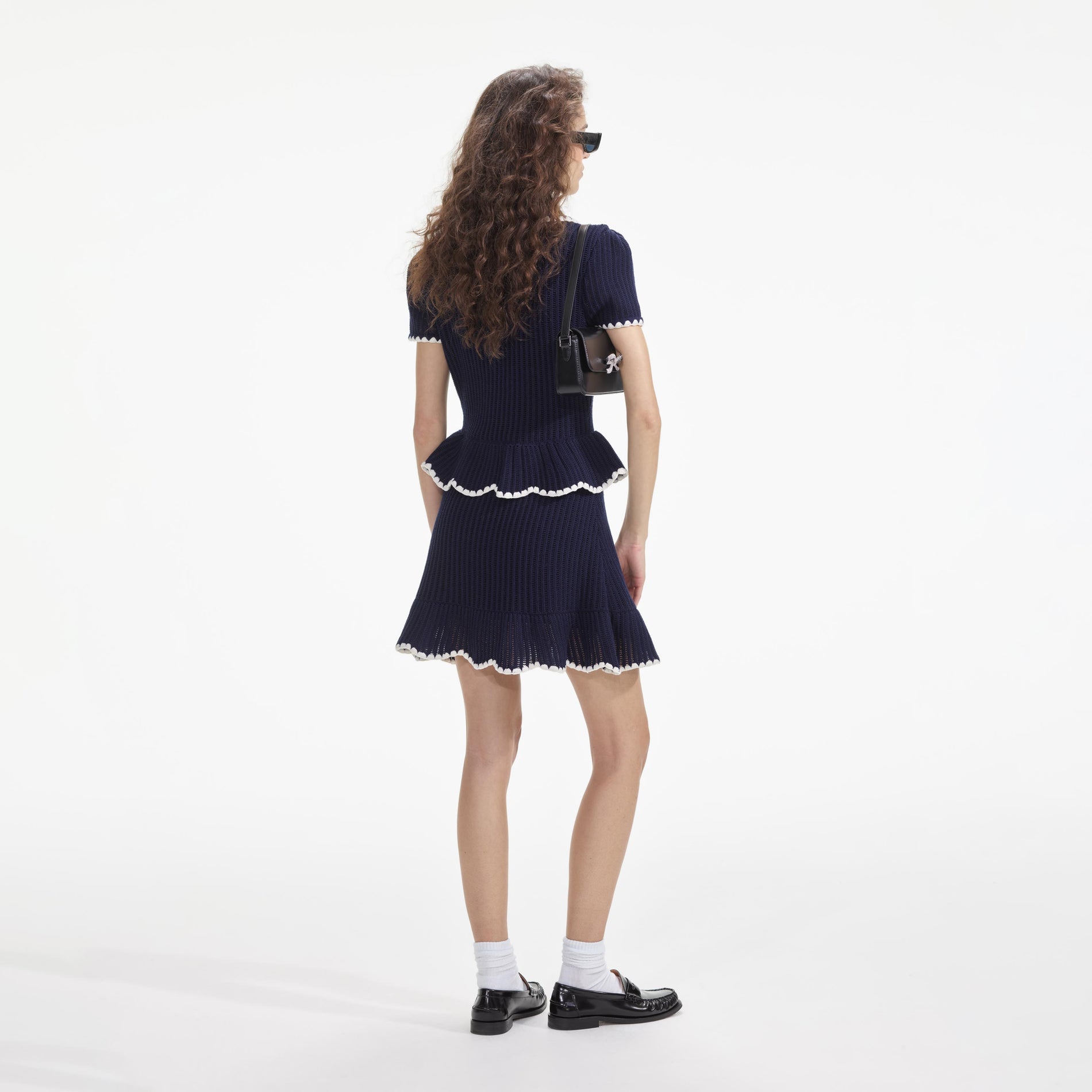 Back view of a woman wearing the Navy Crochet Flared Mini Dress