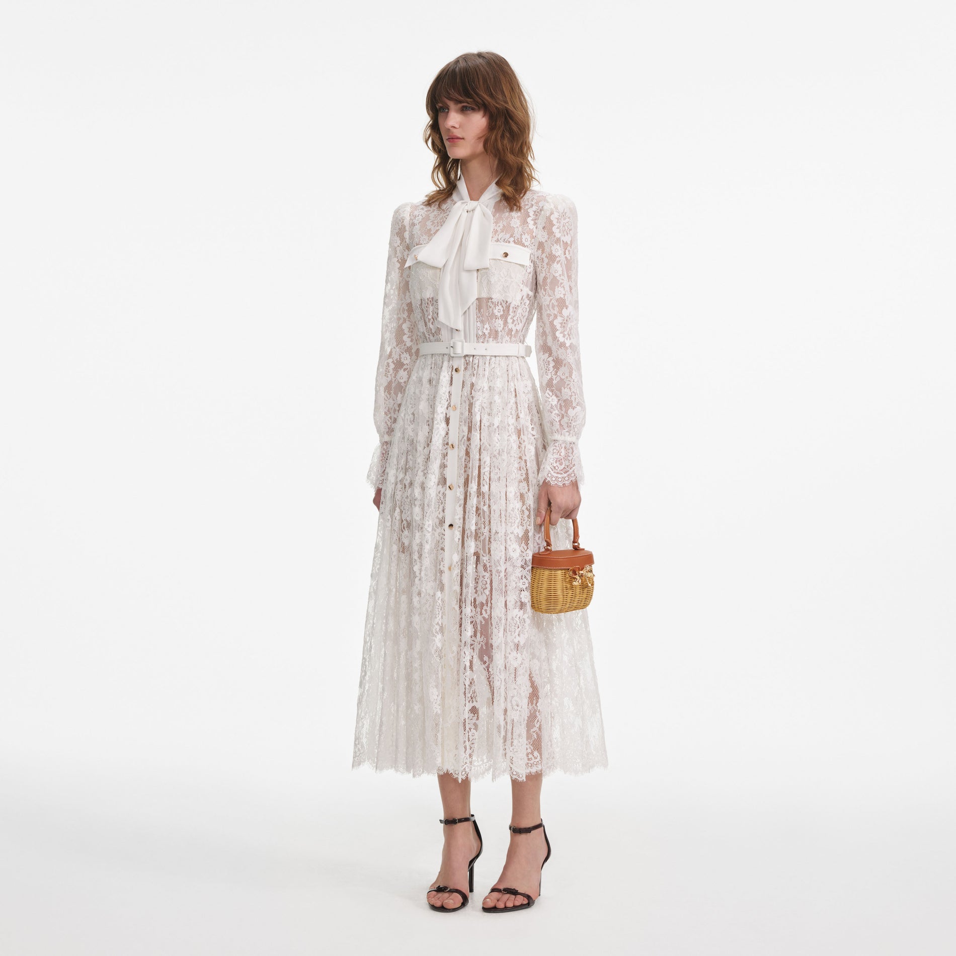 Side view of a woman wearing the White Lace Pussy Bow Midi Dress