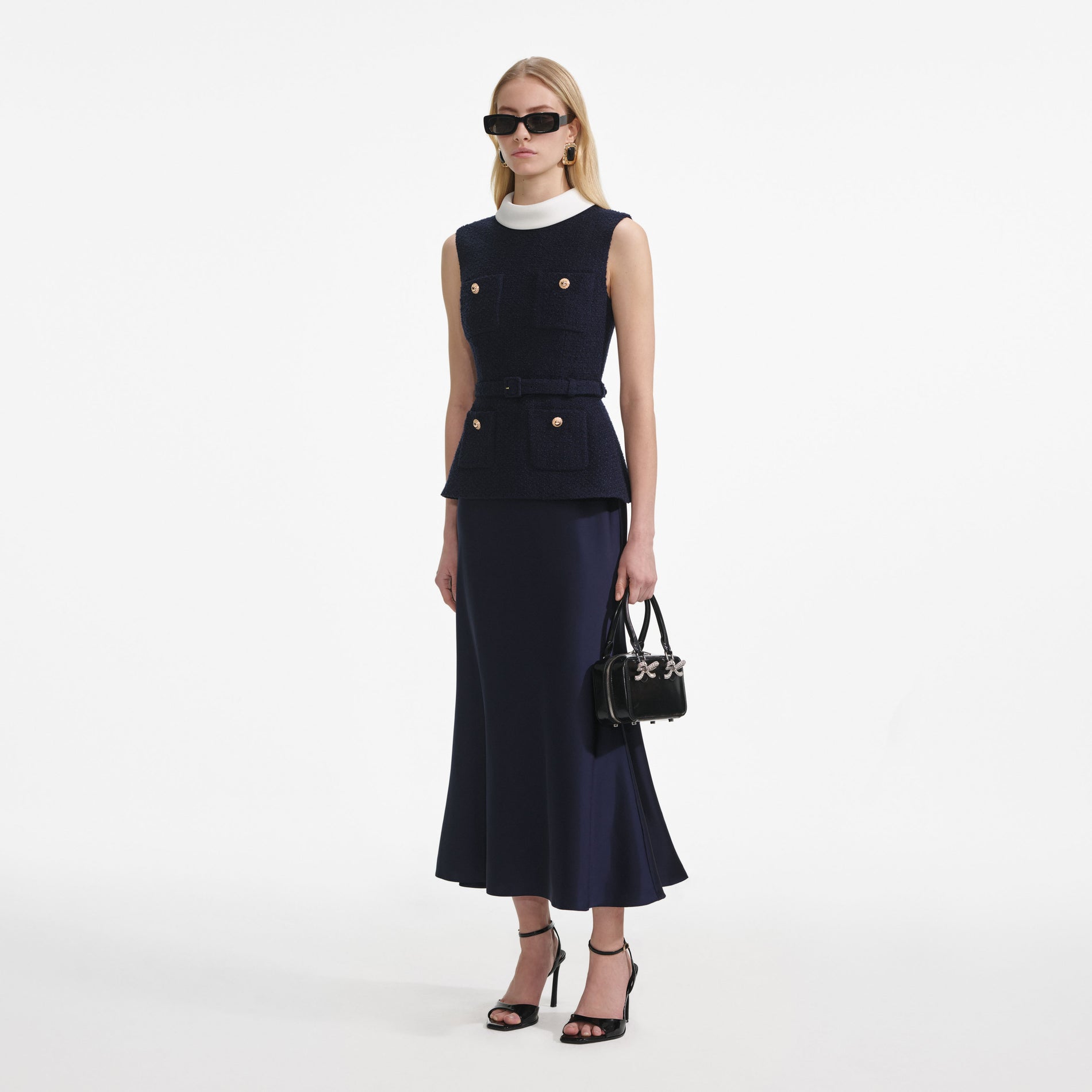 Side view of a woman wearing the Navy Boucle Sleeveless Midi Dress