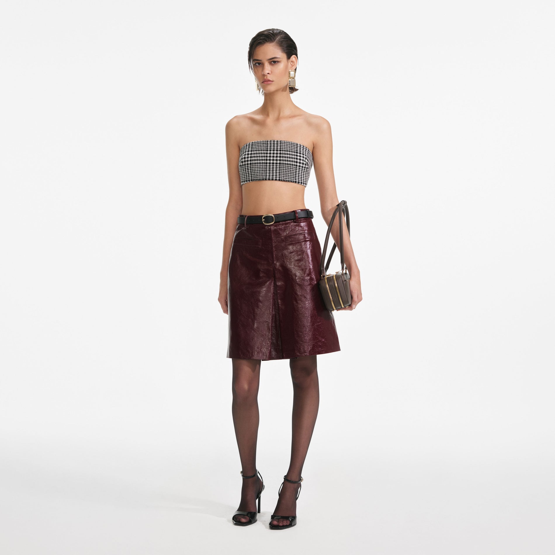 Side view of a woman wearing the Burgundy Leather  Mini Skirt