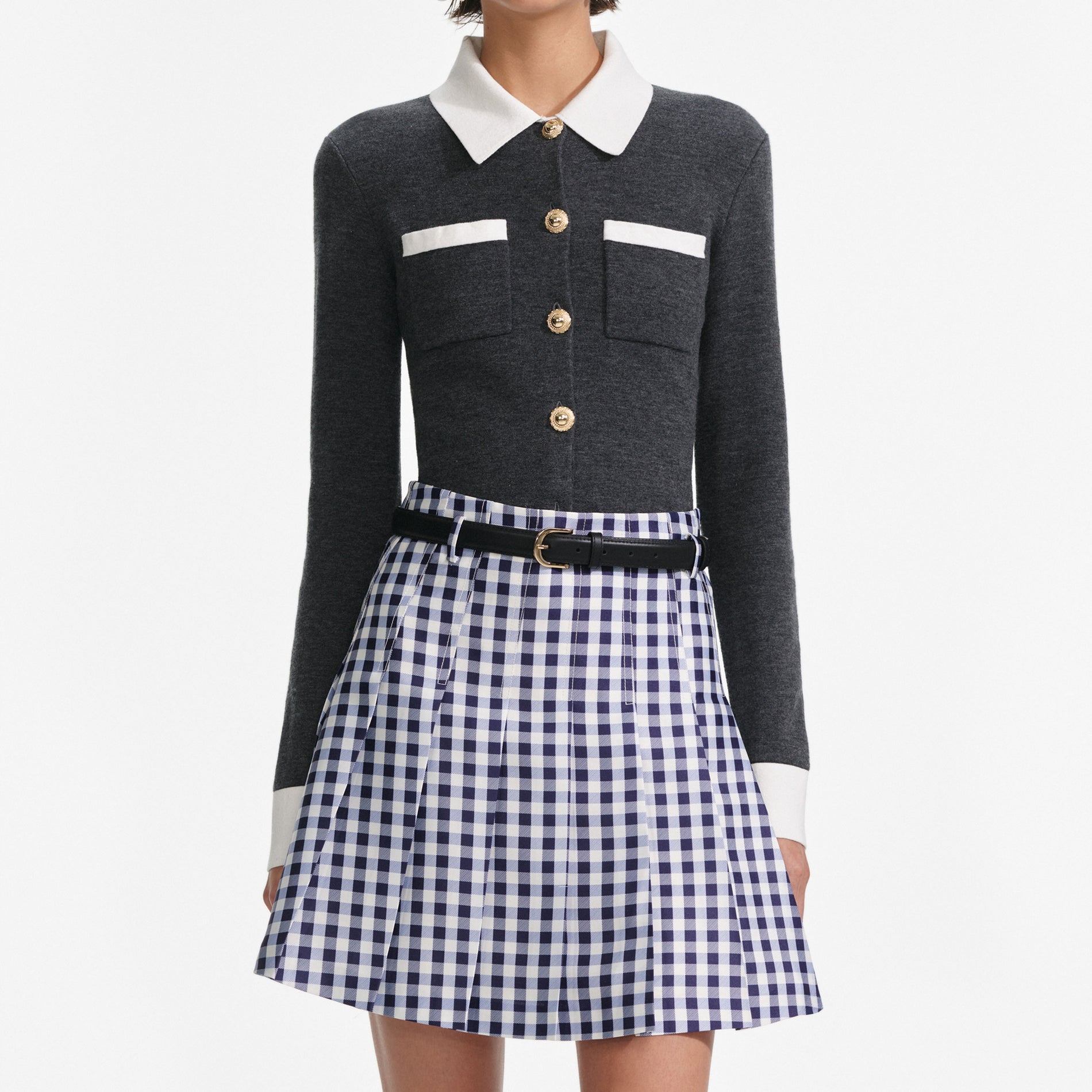 A close up of a woman wearing the Navy Gingham Pleated Taffeta Mini Skirt